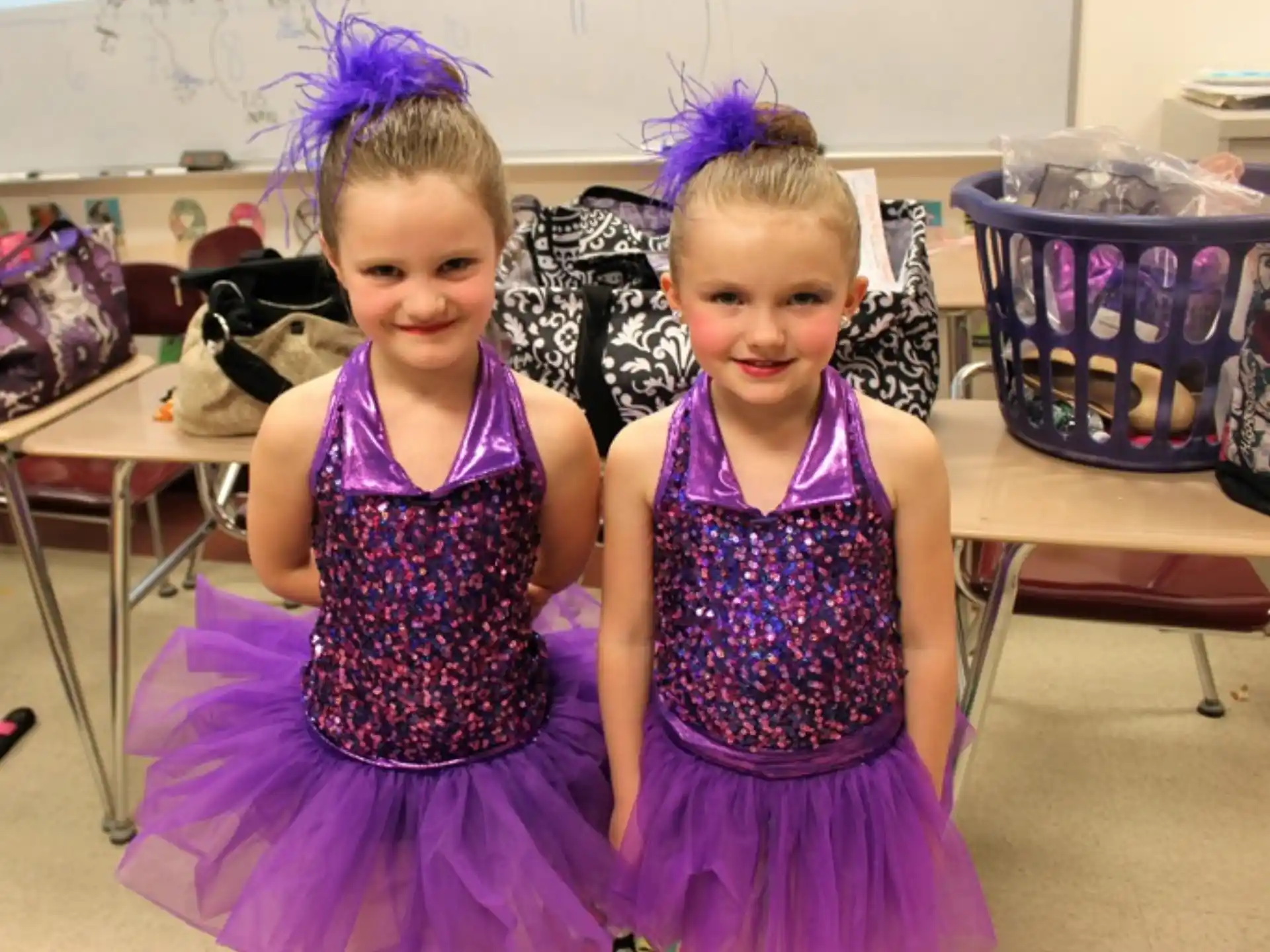 two girls wearing dresses and posing for a picture