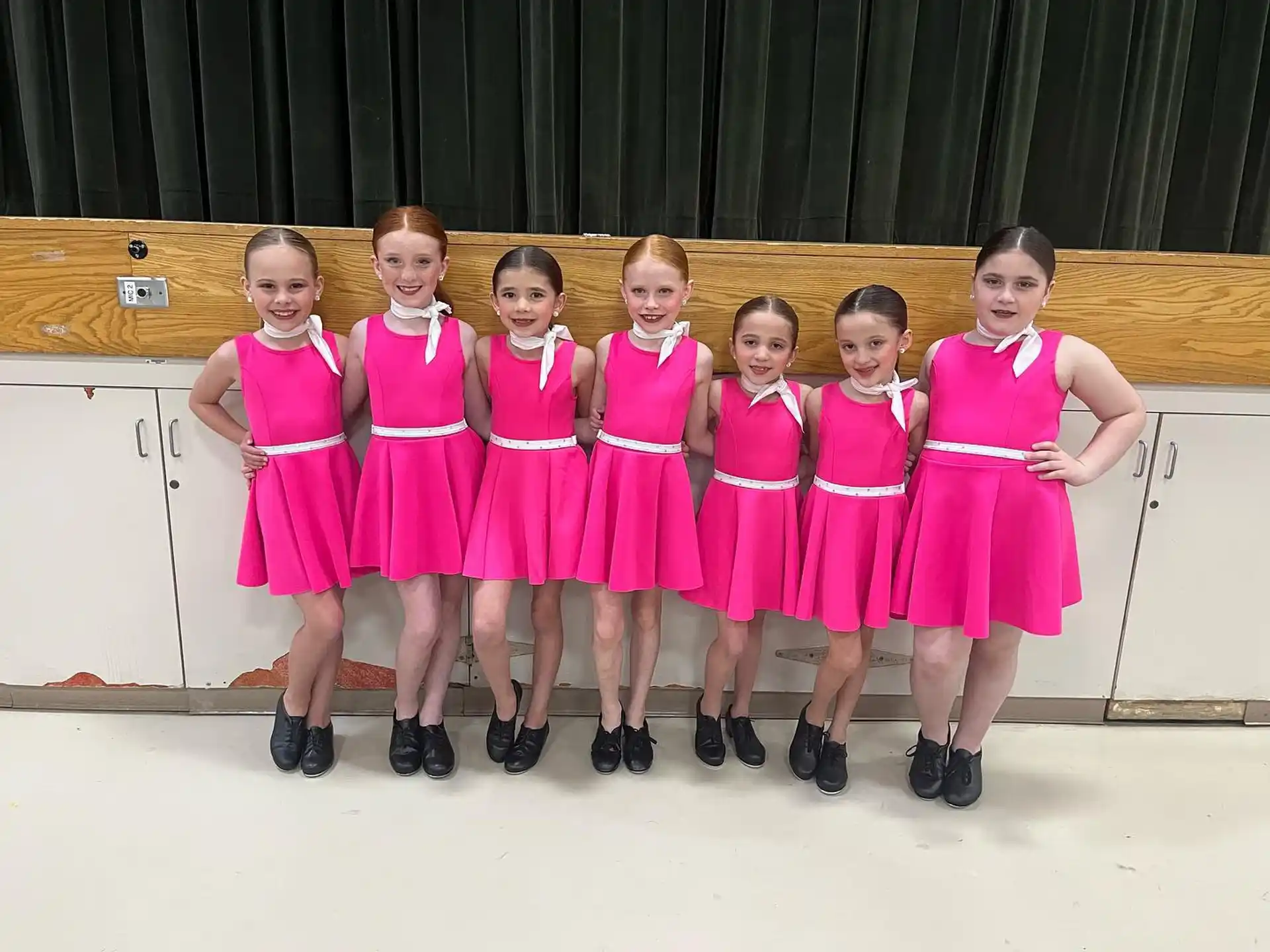 a group of girls in pink dresses