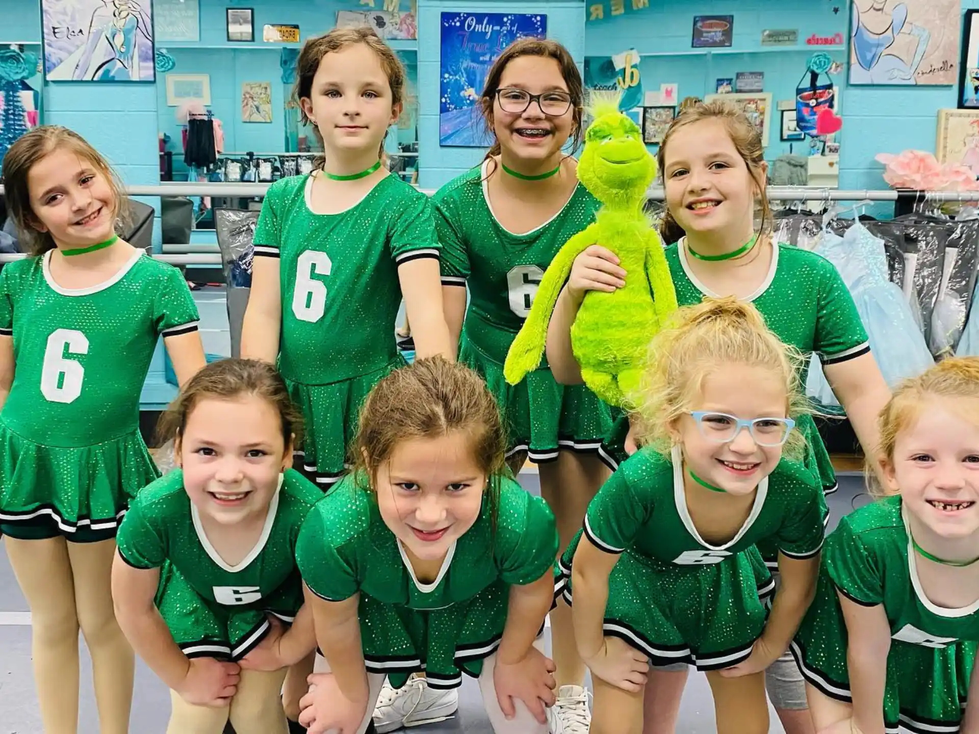 a group of children in green shirts