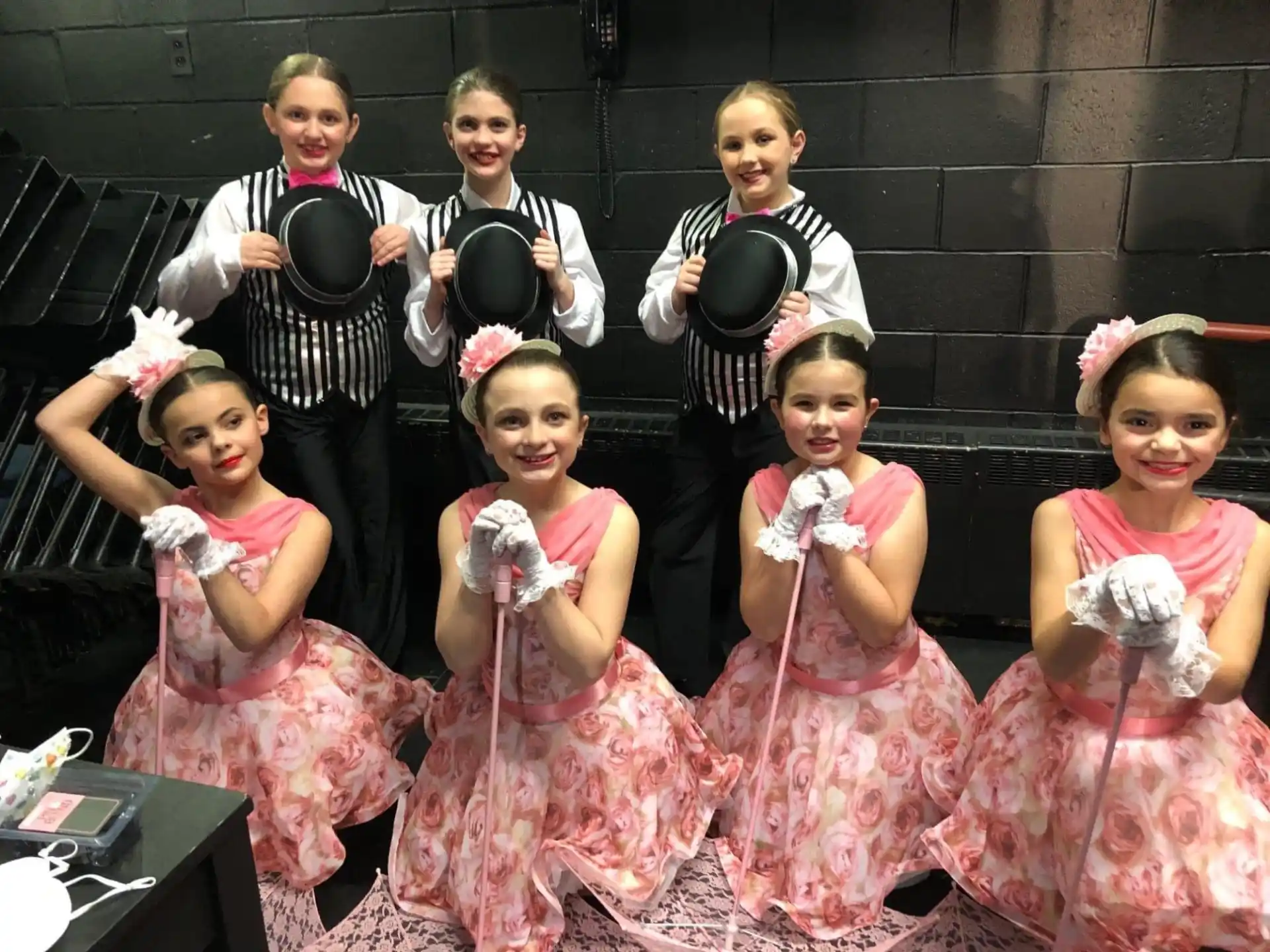 a group of children in dresses and tuxedos