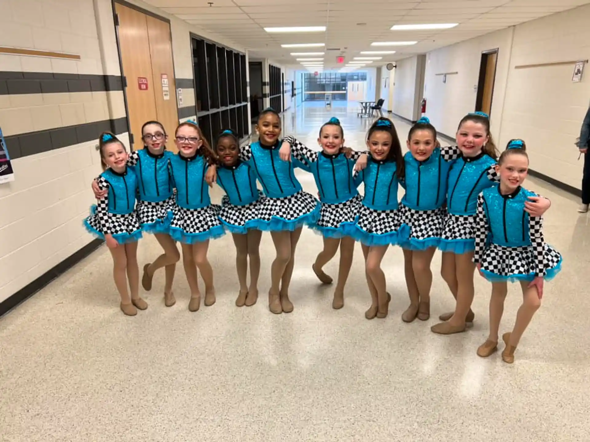 a group of girls in matching blue and white dresses
