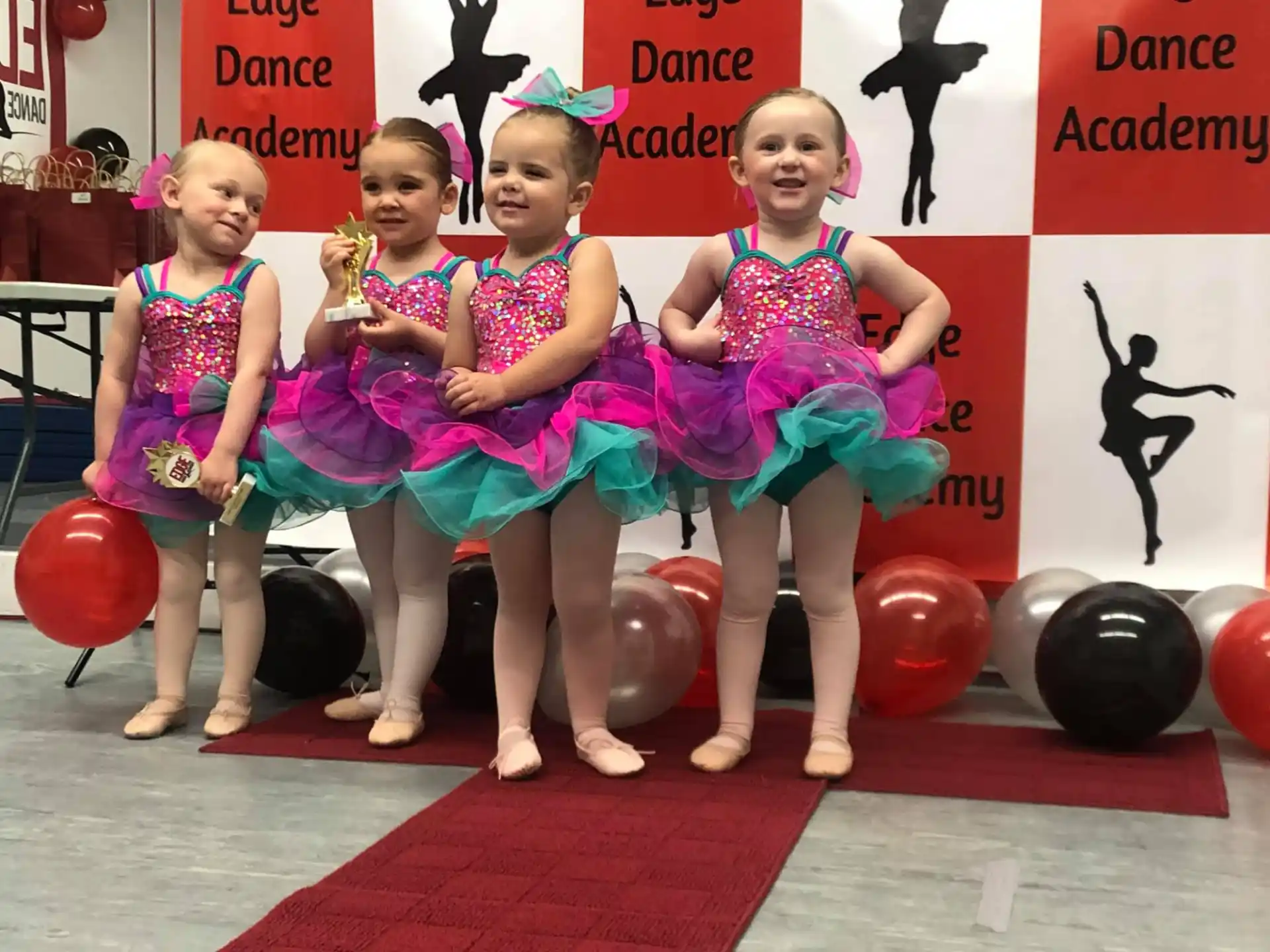 a group of girls in colorful dresses