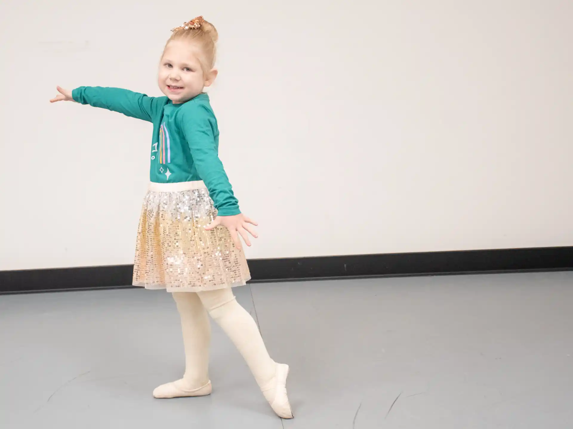 a girl in a green shirt and skirt dancing