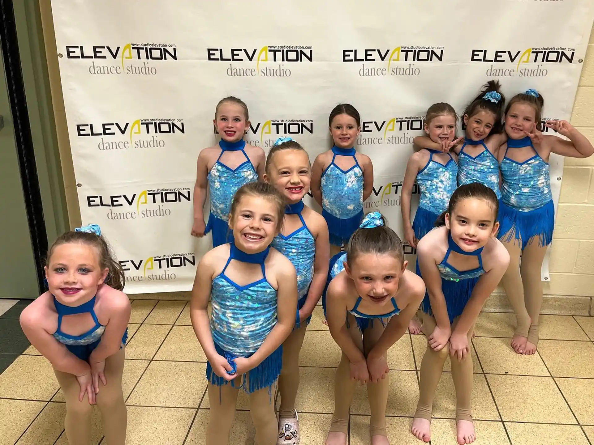 a group of girls in blue swimsuits posing for a photo