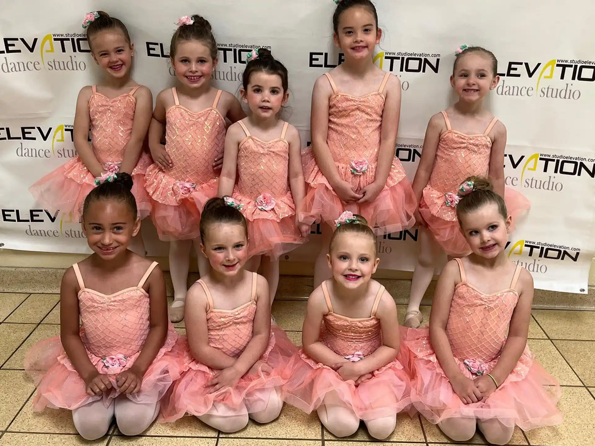 a group of girls in pink dresses