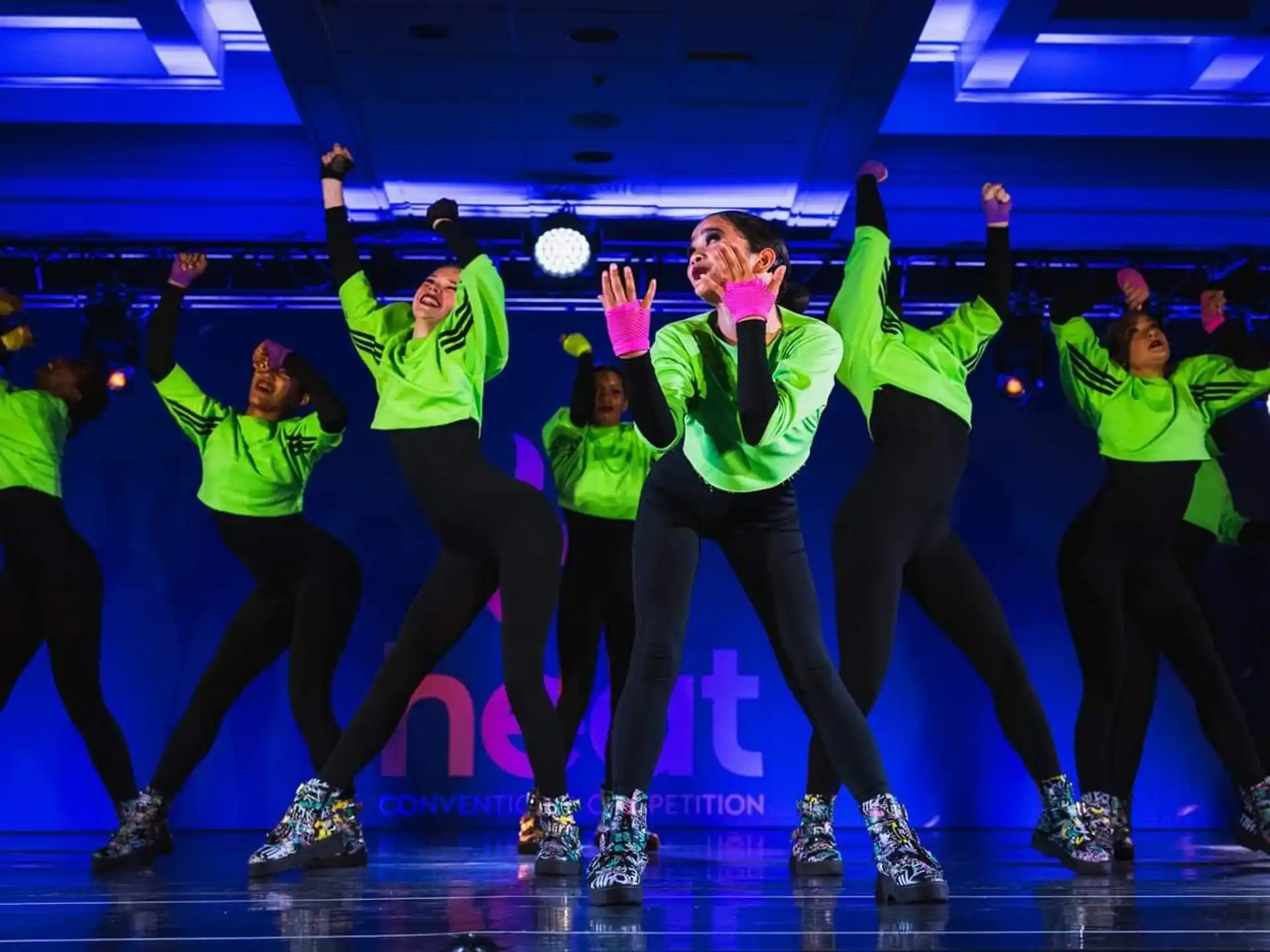 a group of people wearing green shirts and ice skates