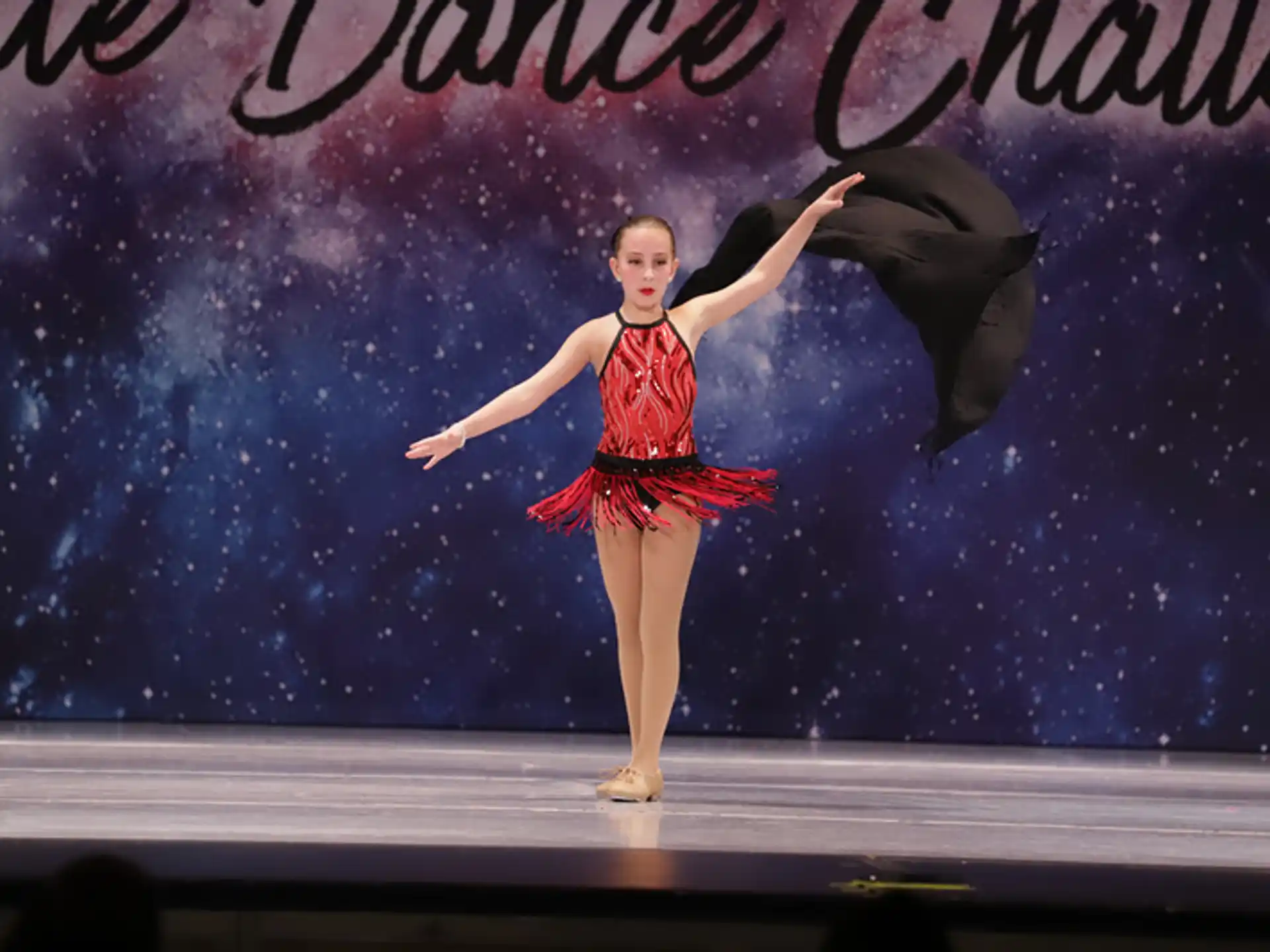 a person in a red dress dancing on a stage