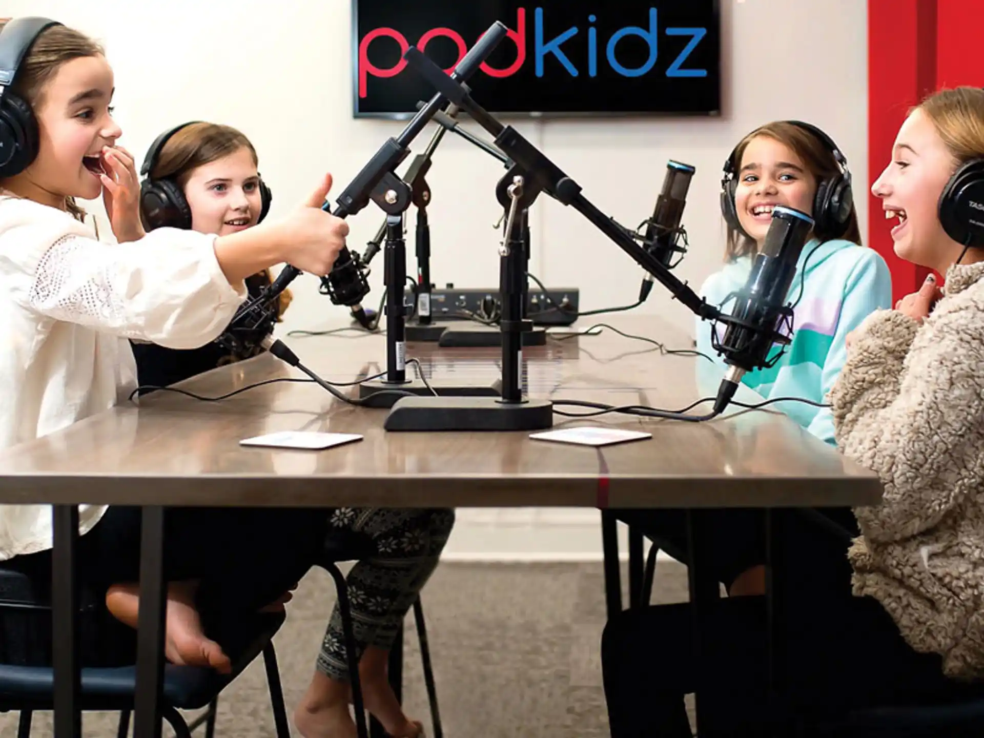 a group of women sitting at a table with microphones