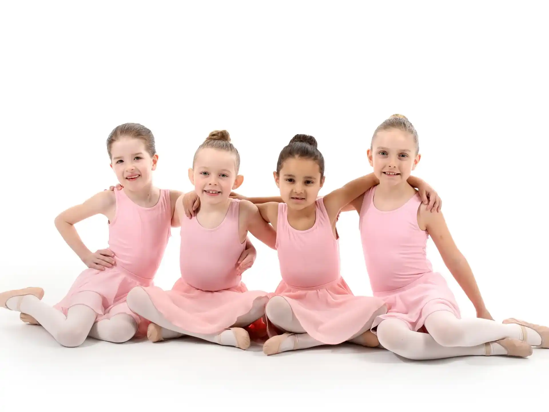 a group of children sitting together smiling
