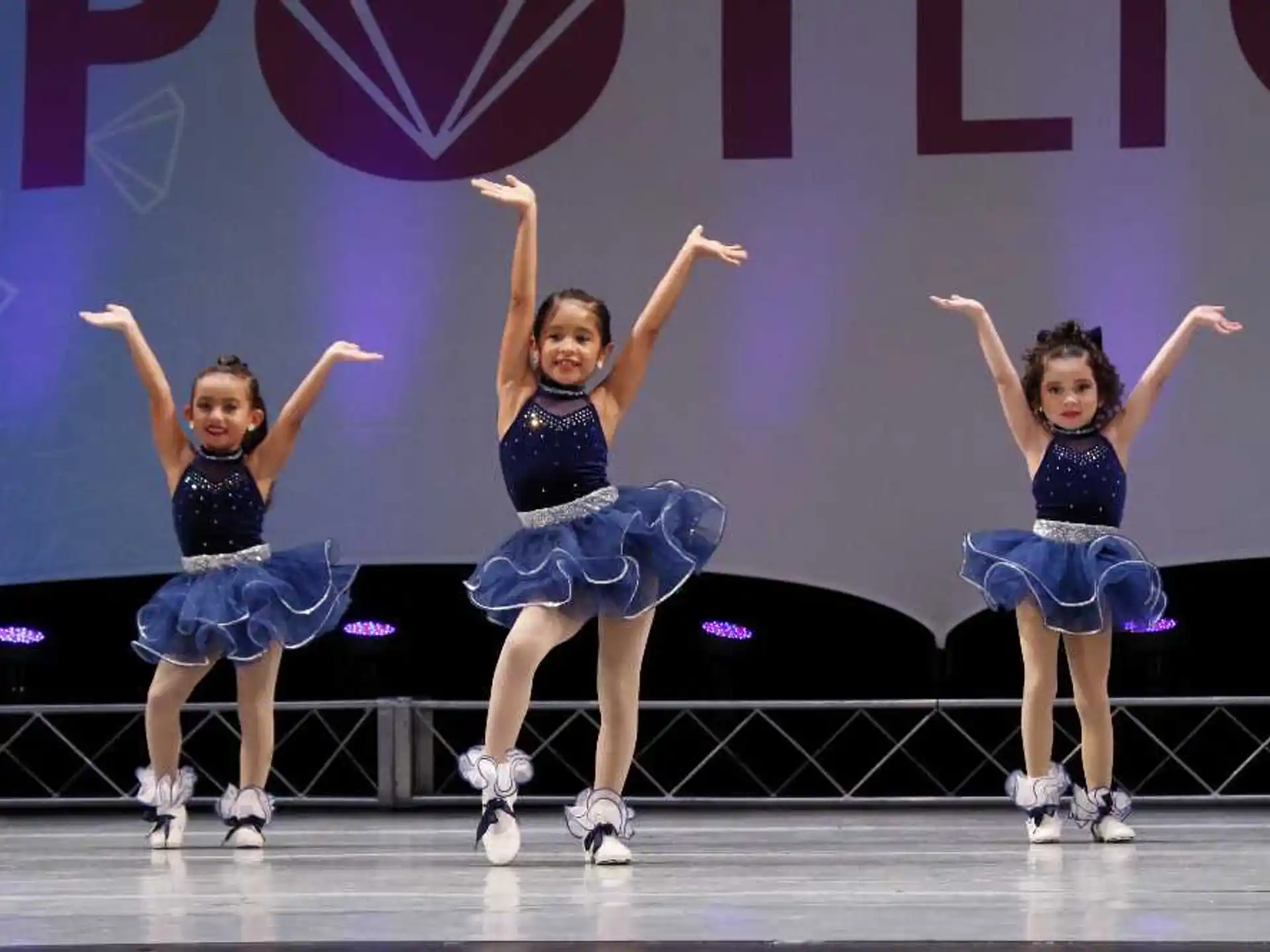 a group of girls dancing on a stage