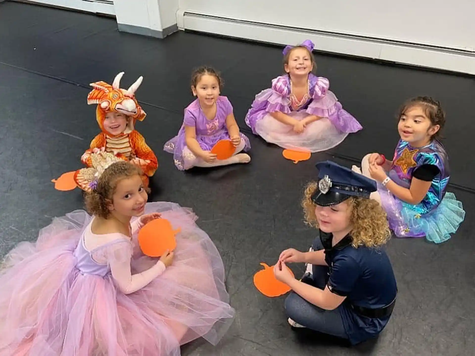 a group of children sitting on the ground with toys