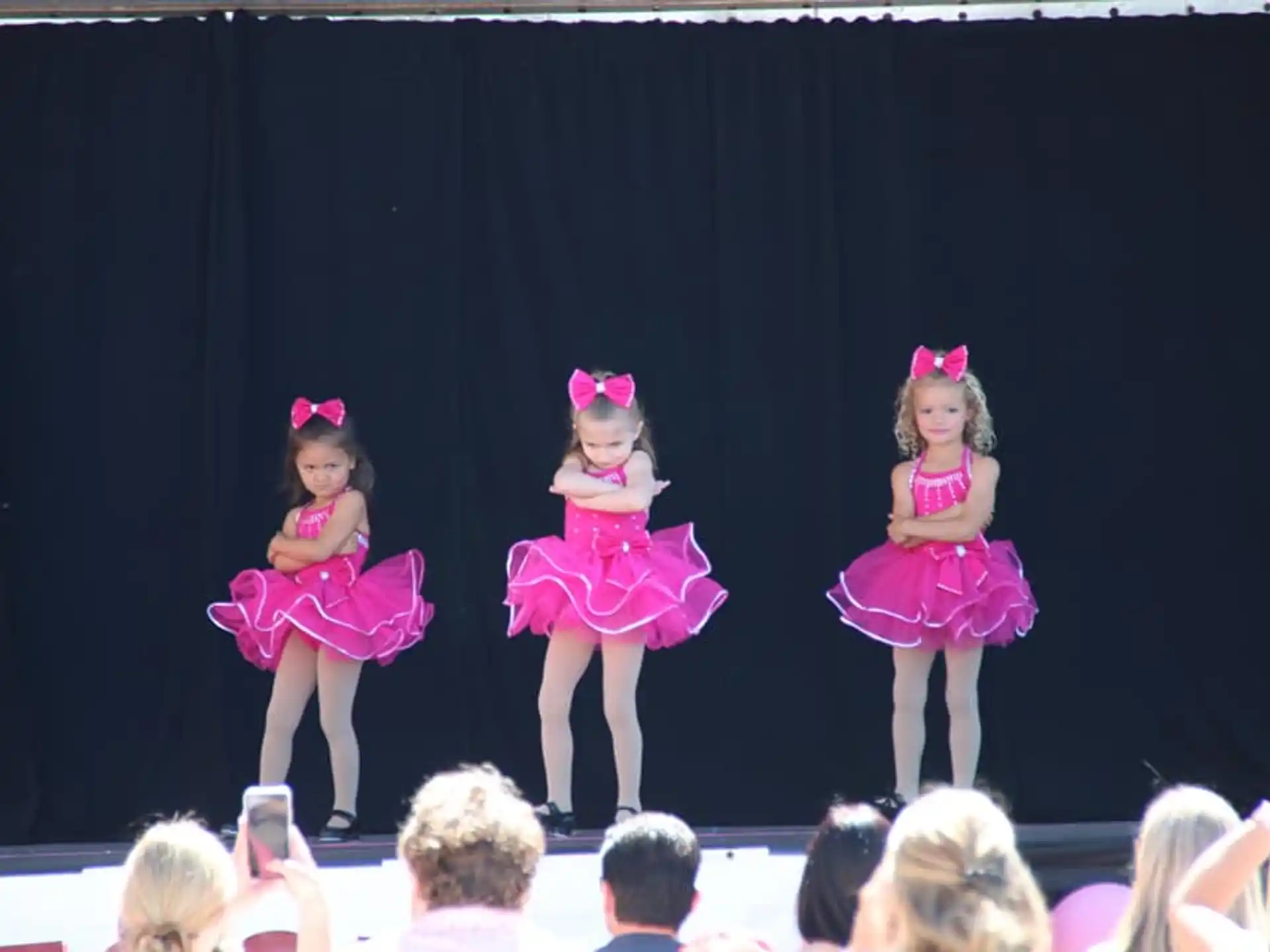 a group of girls in dresses on a stage