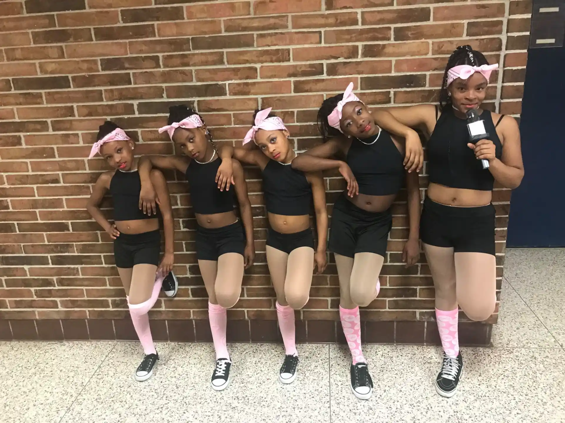 a group of women wearing black and pink hats and posing for a photo