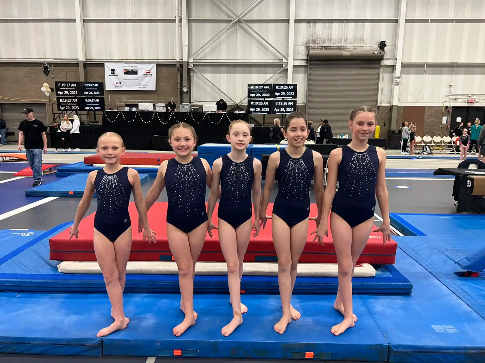 a group of women in swimsuits standing on a mat in a swimming pool