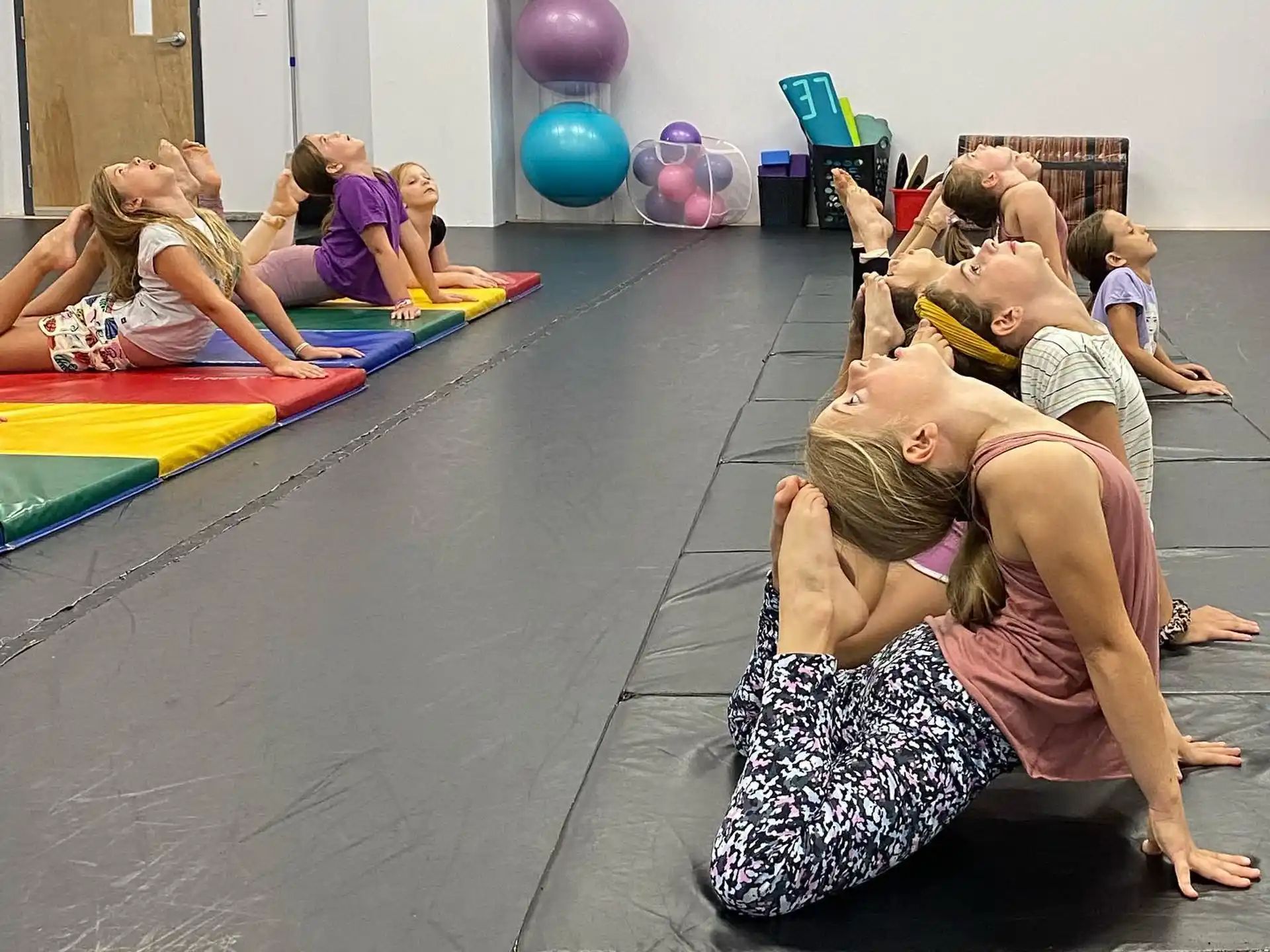 a group of people sitting on the floor with balloons