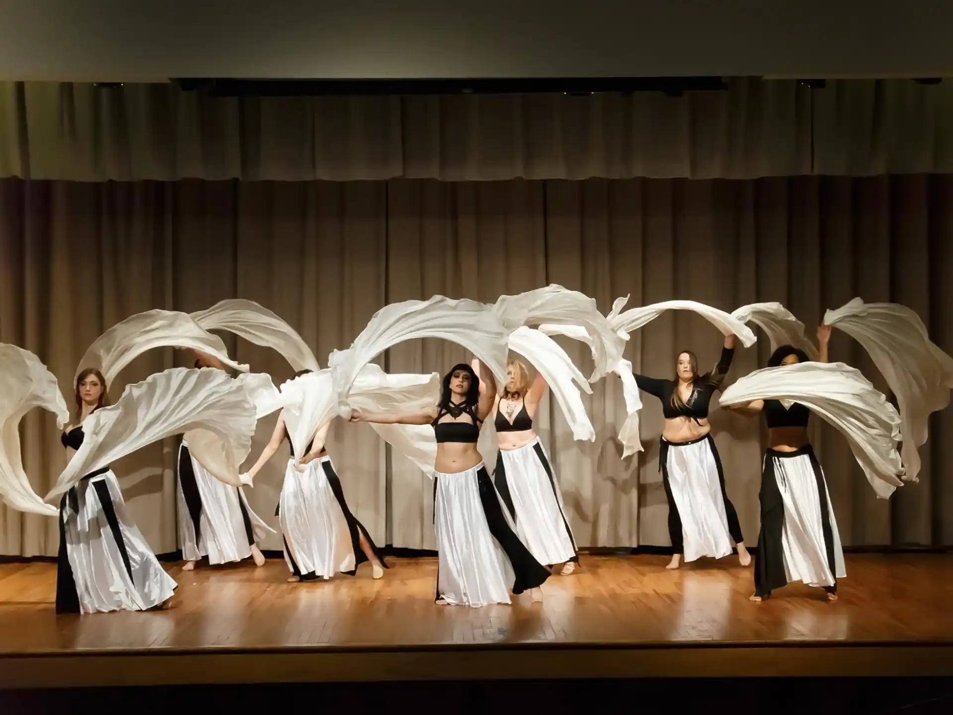 a group of women in white dresses holding white wings