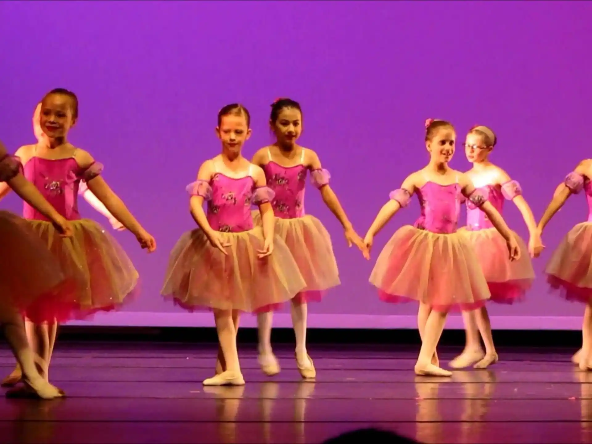 a group of girls dancing on a stage