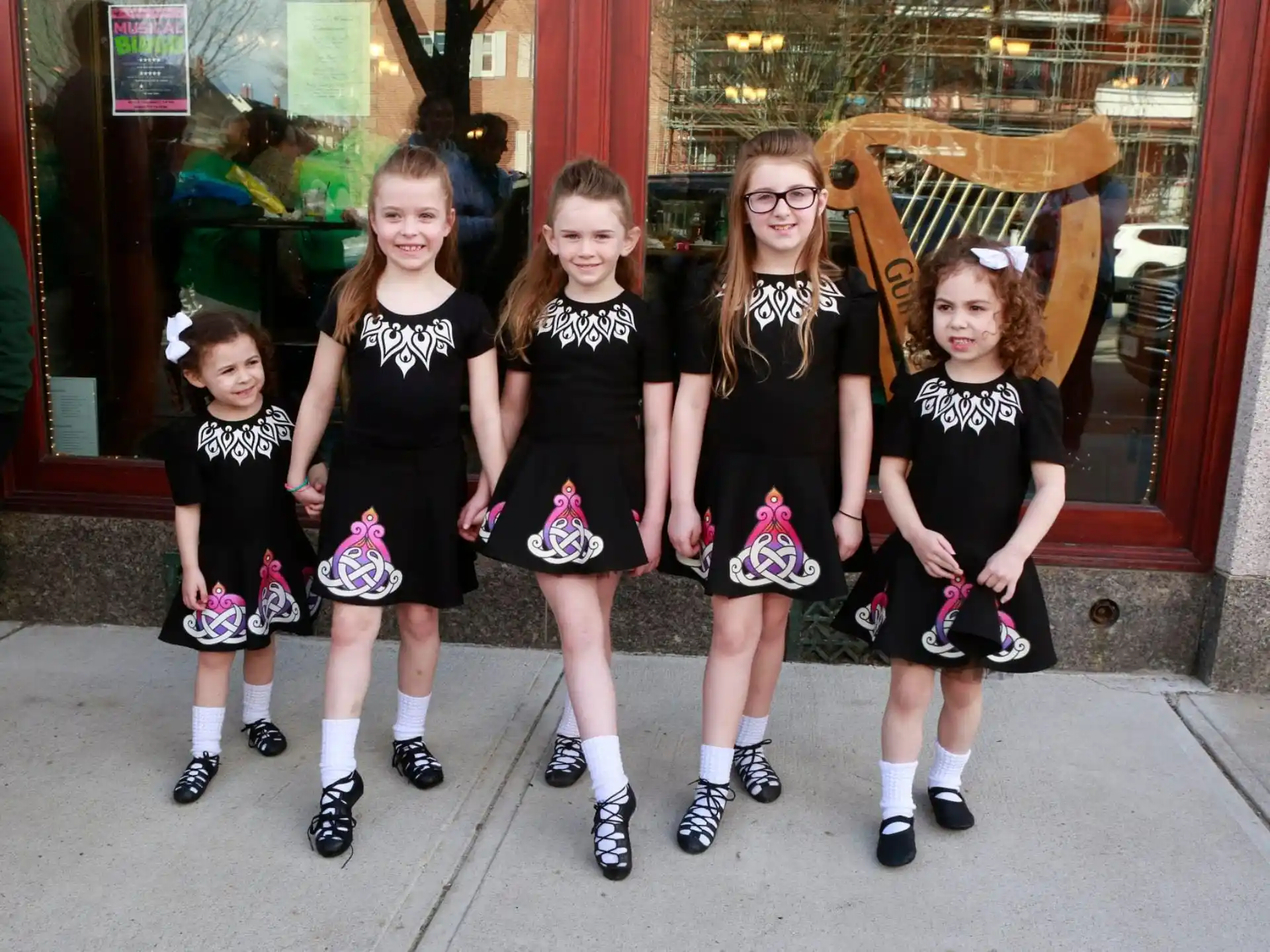 a group of girls in black and white dresses posing for a photo
