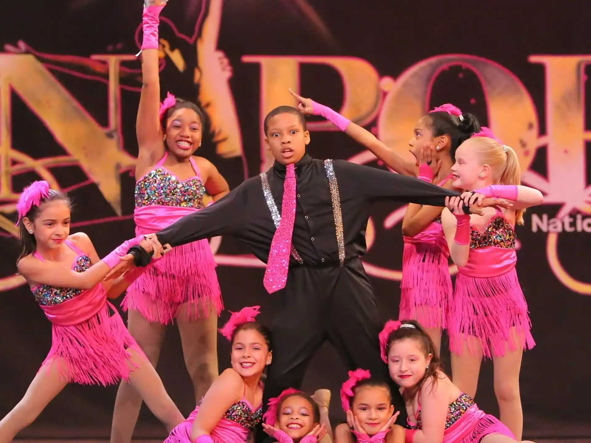 a person and a group of girls on a stage