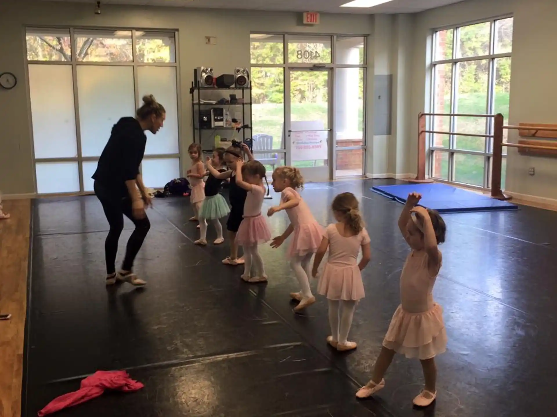 a person and a group of children exercising in a room