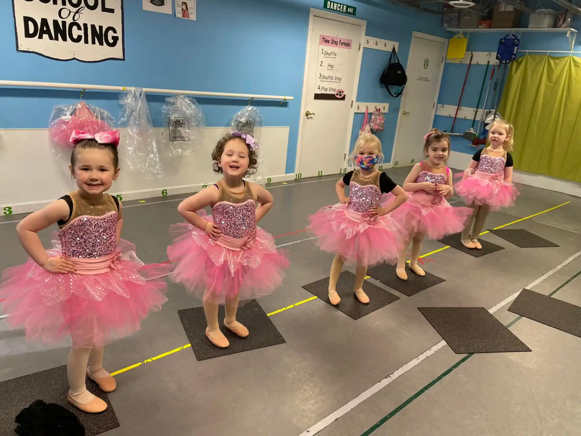 a group of girls in dresses dancing
