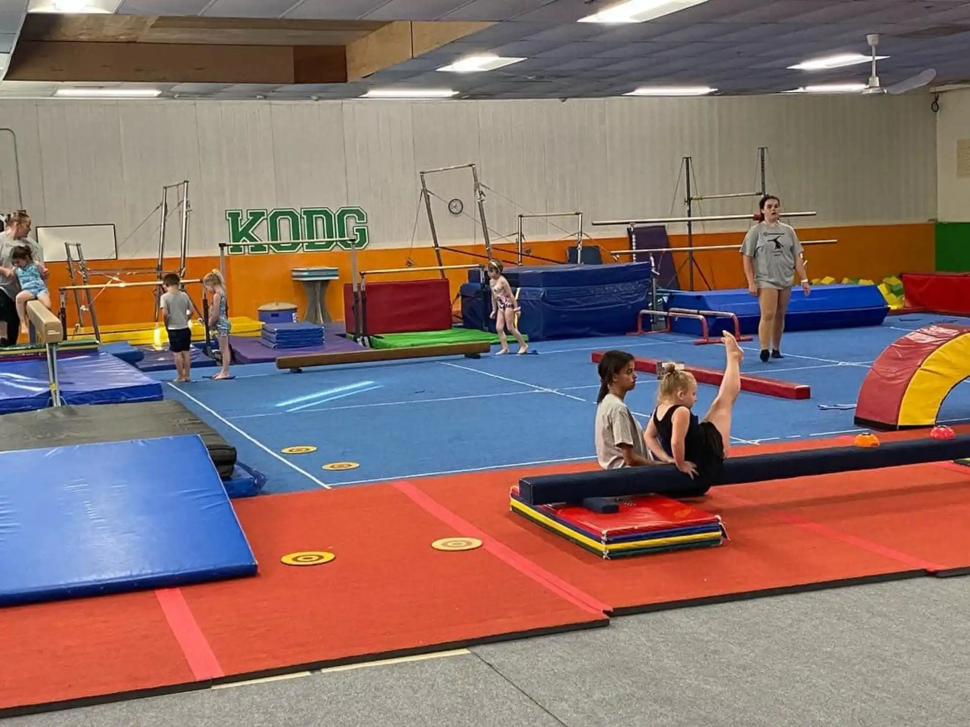 a group of people playing ping pong in a room with a large screen