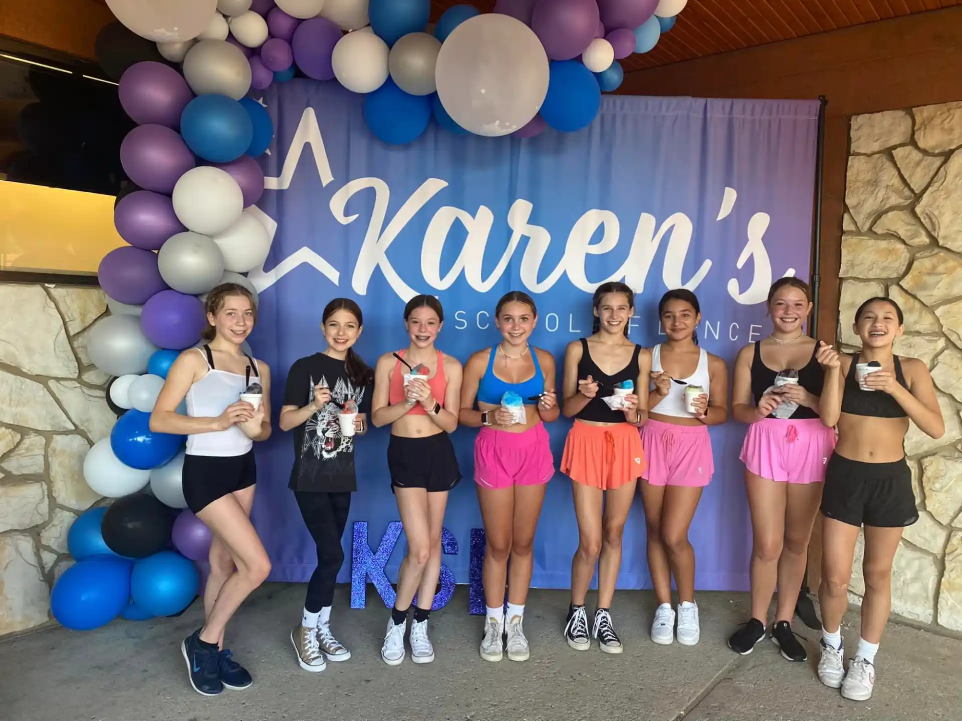 a group of women posing for a photo with balloons