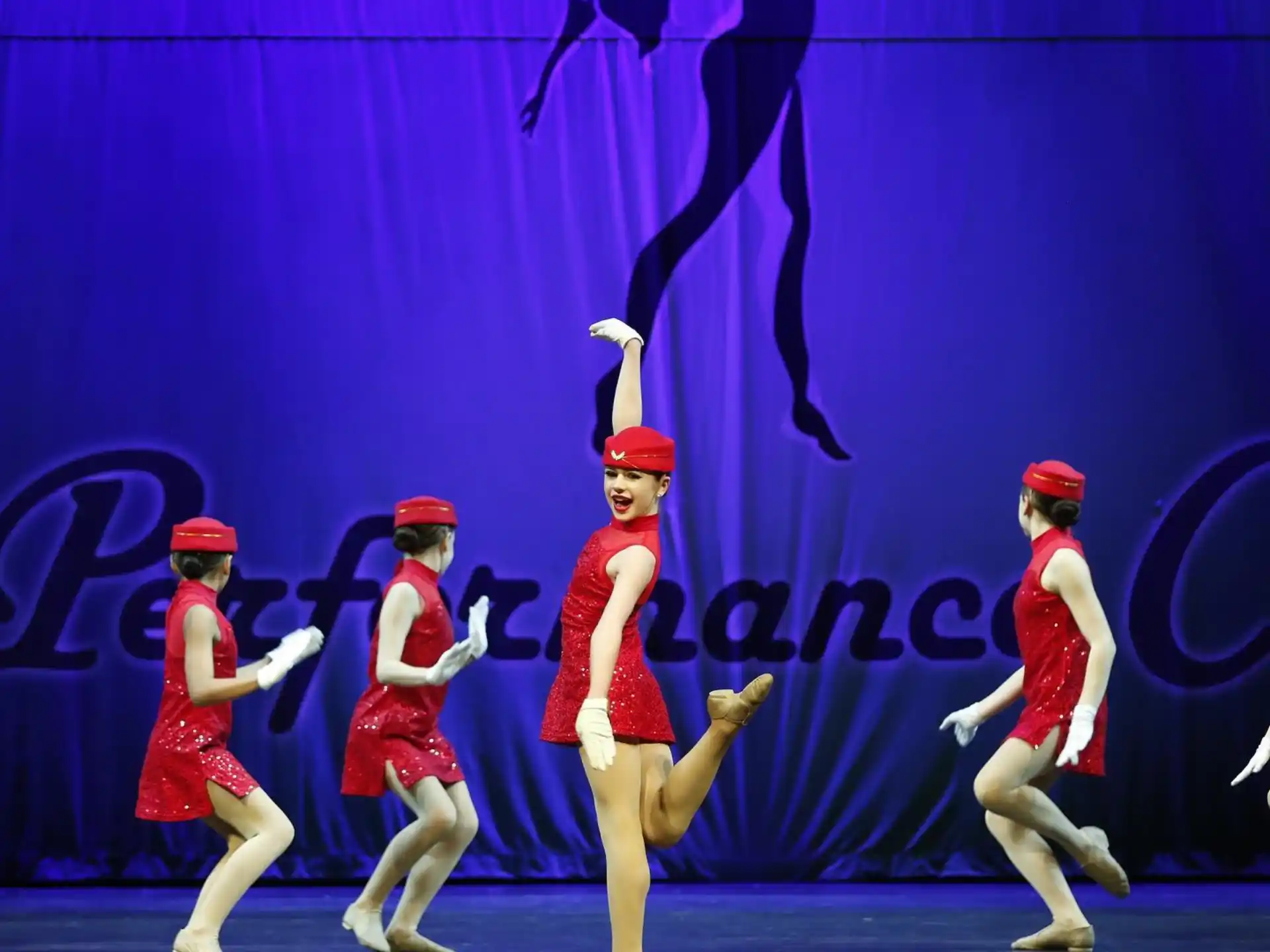 a group of women in red and white uniforms on a stage