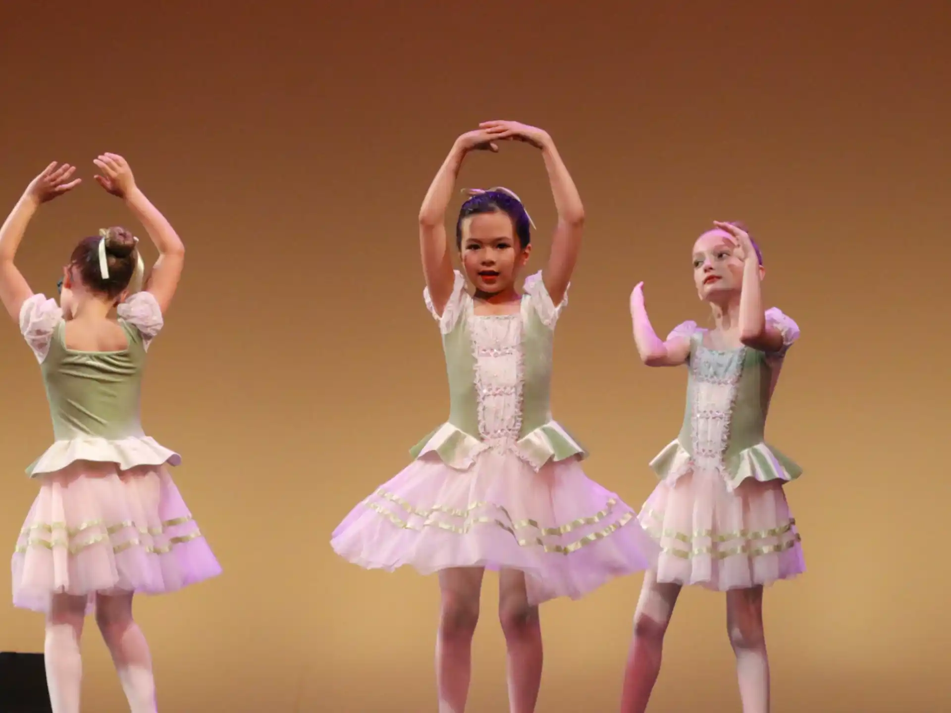 a group of girls wearing dresses and dancing