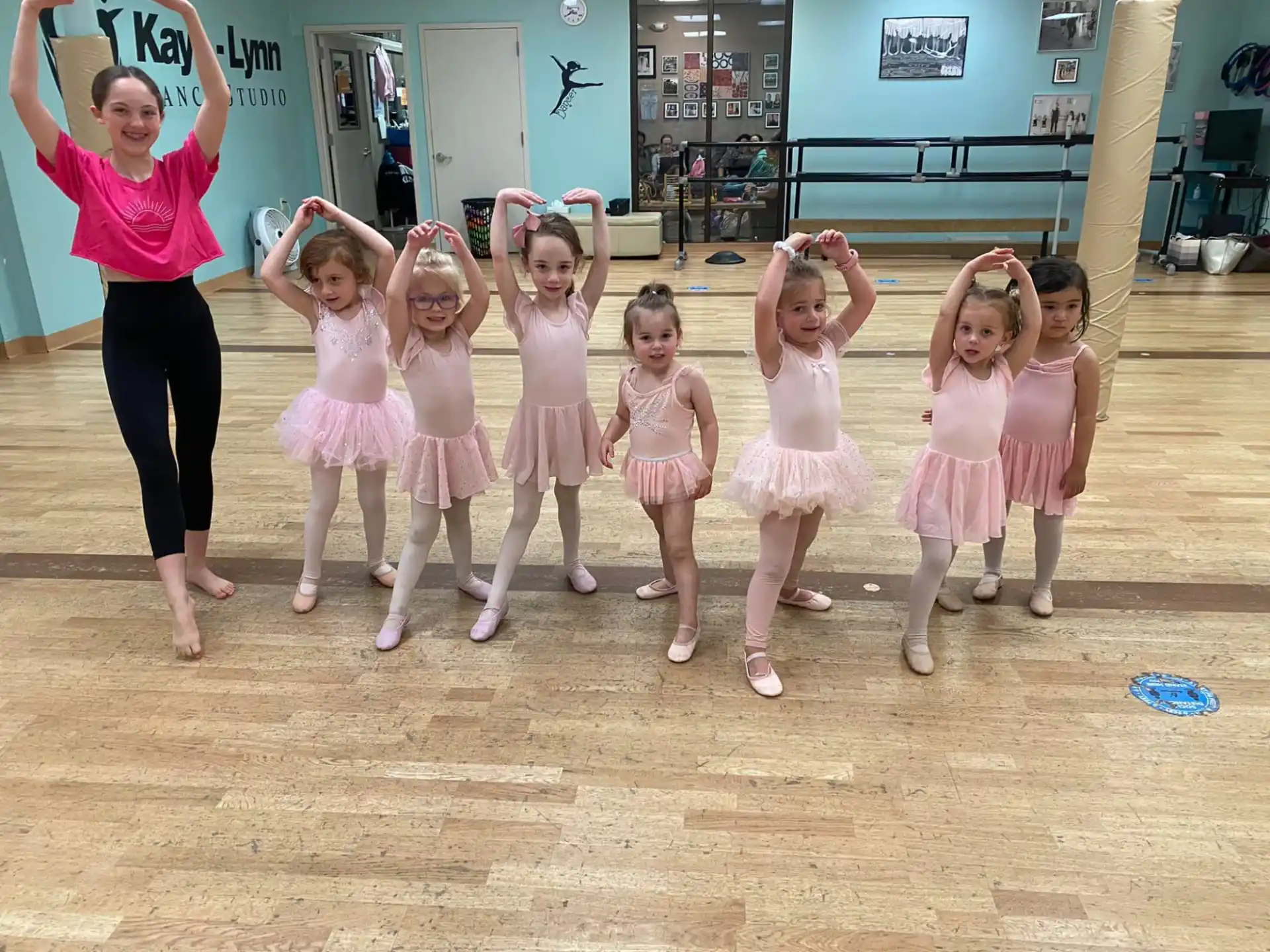 a person standing with a group of girls in a room