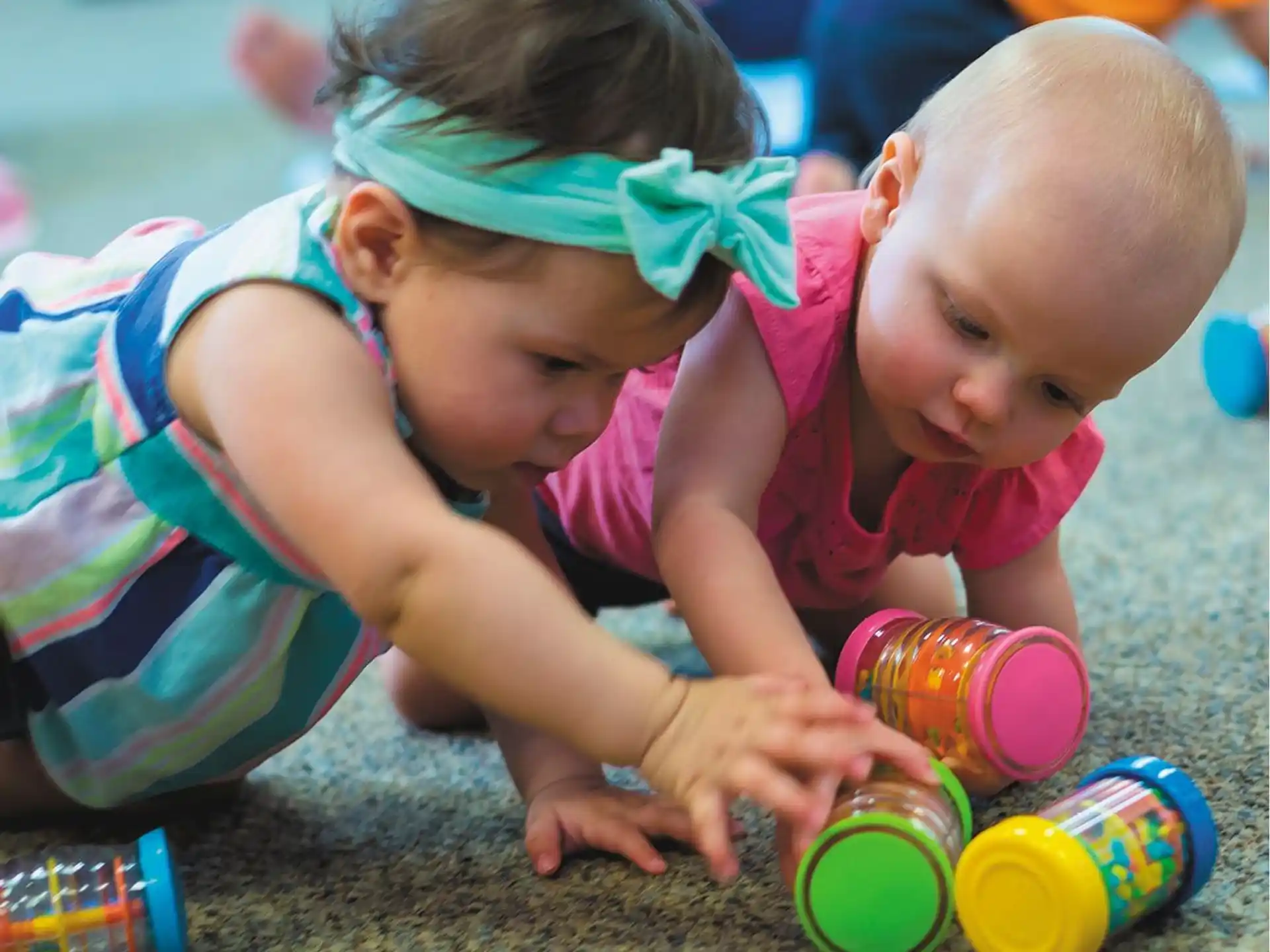 a baby and a person playing with toys