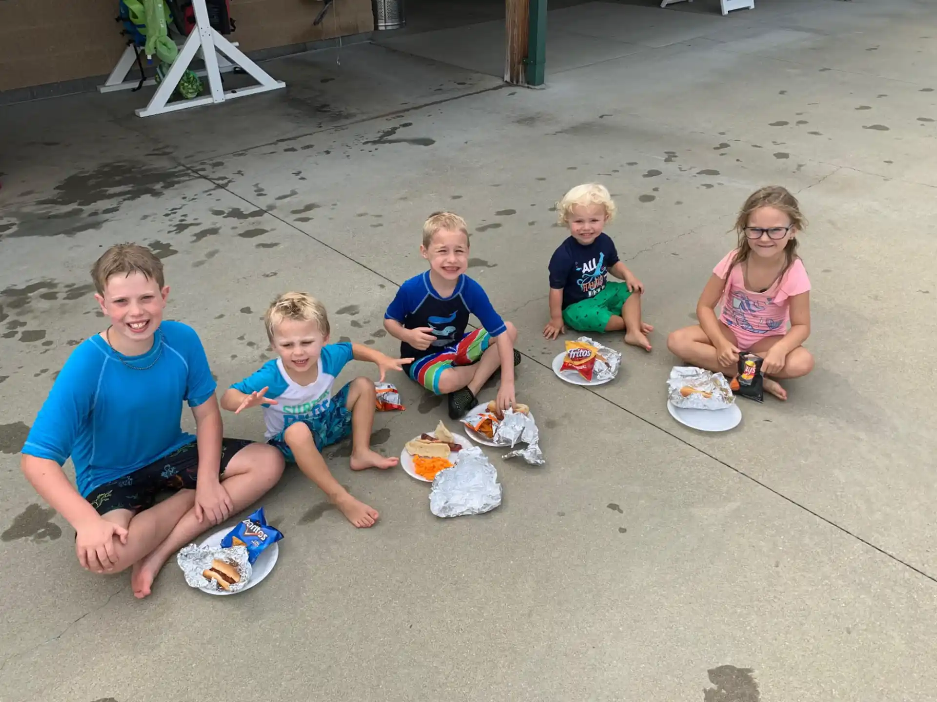 a group of kids sitting on the sand