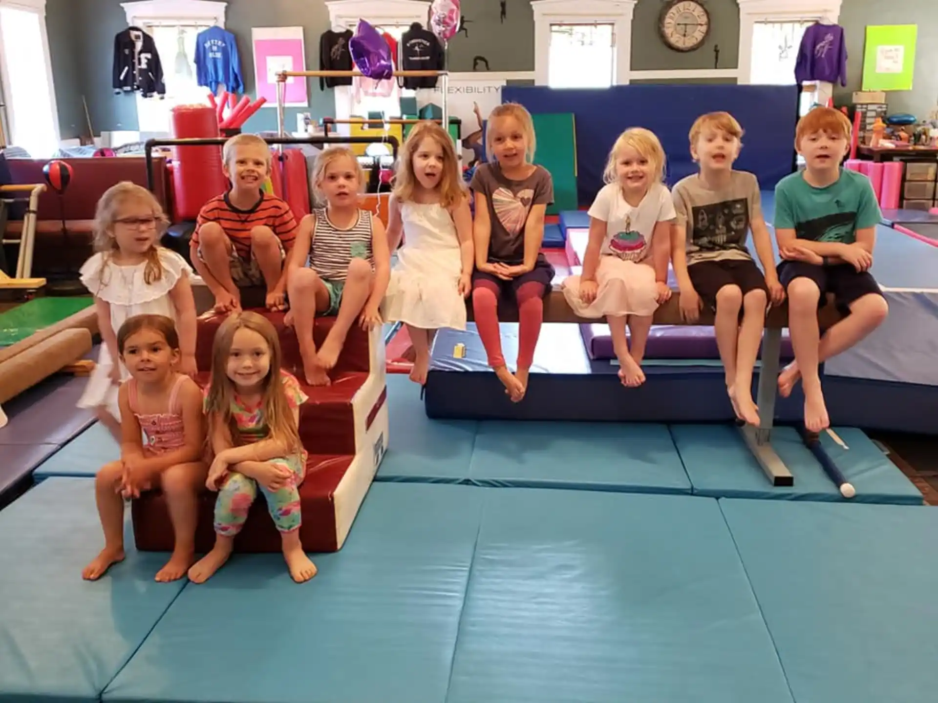 a group of children sitting on a bench in a room