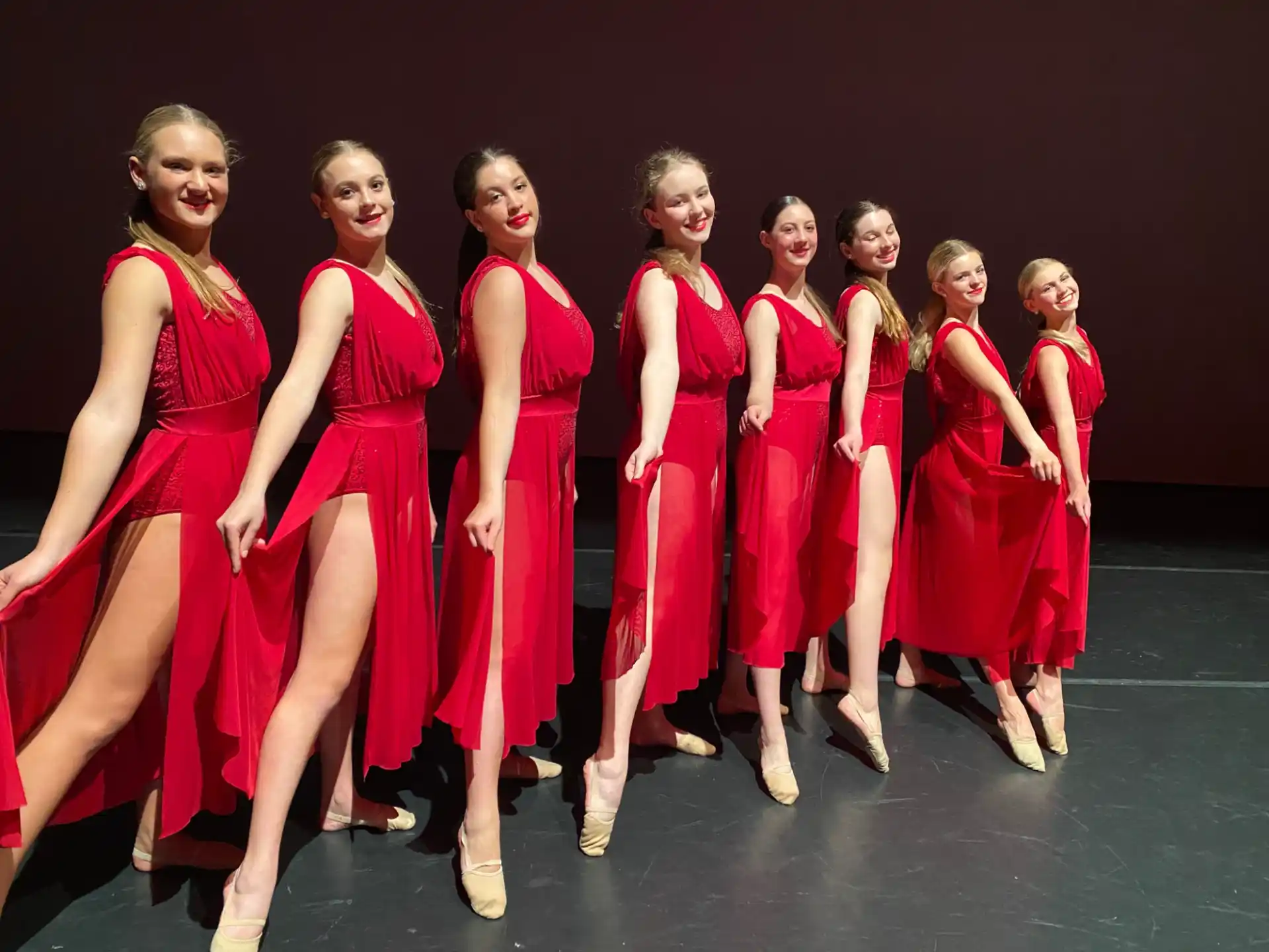 a group of women in red dresses
