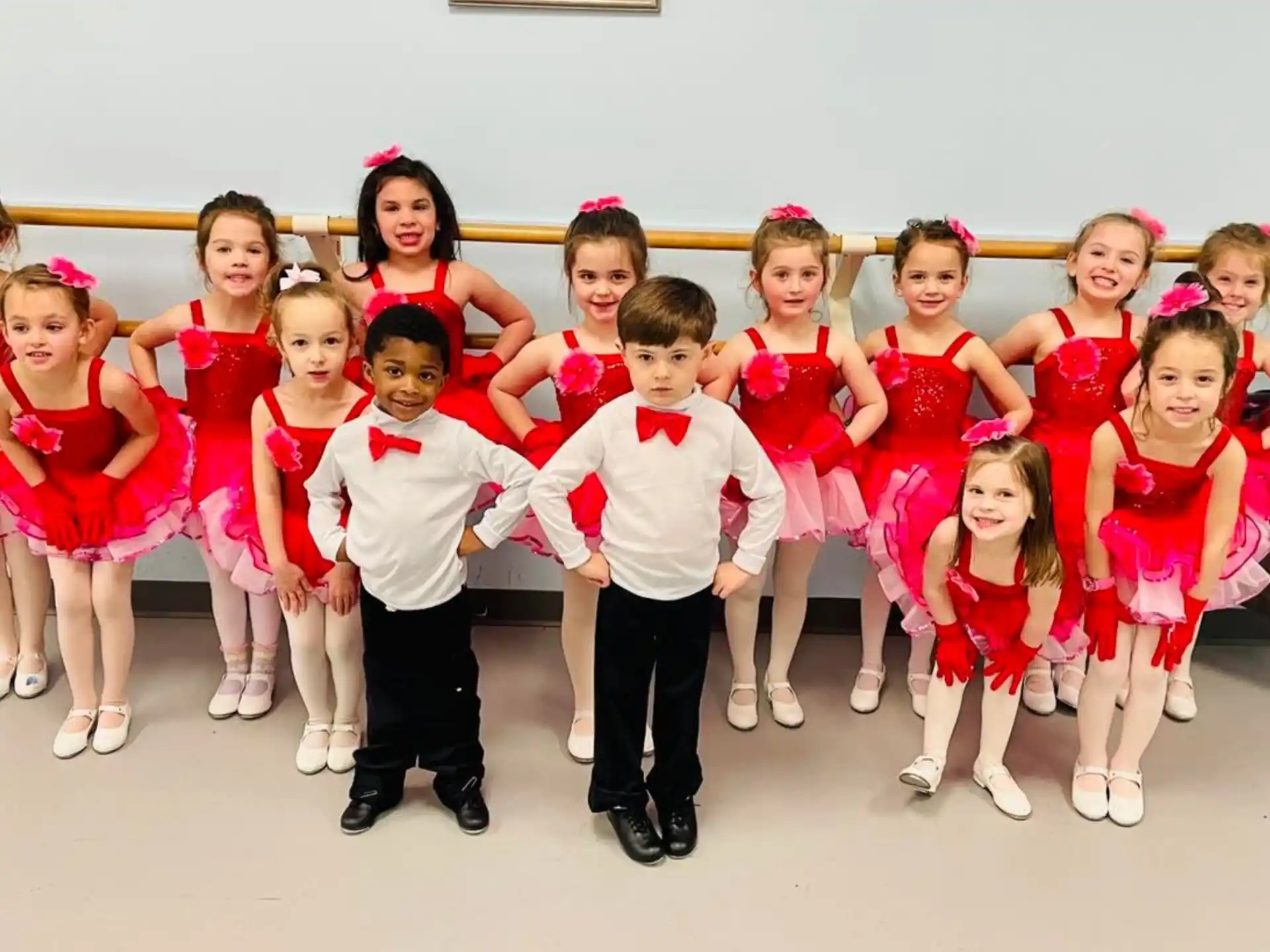 a group of children in red and white dresses posing for a photo