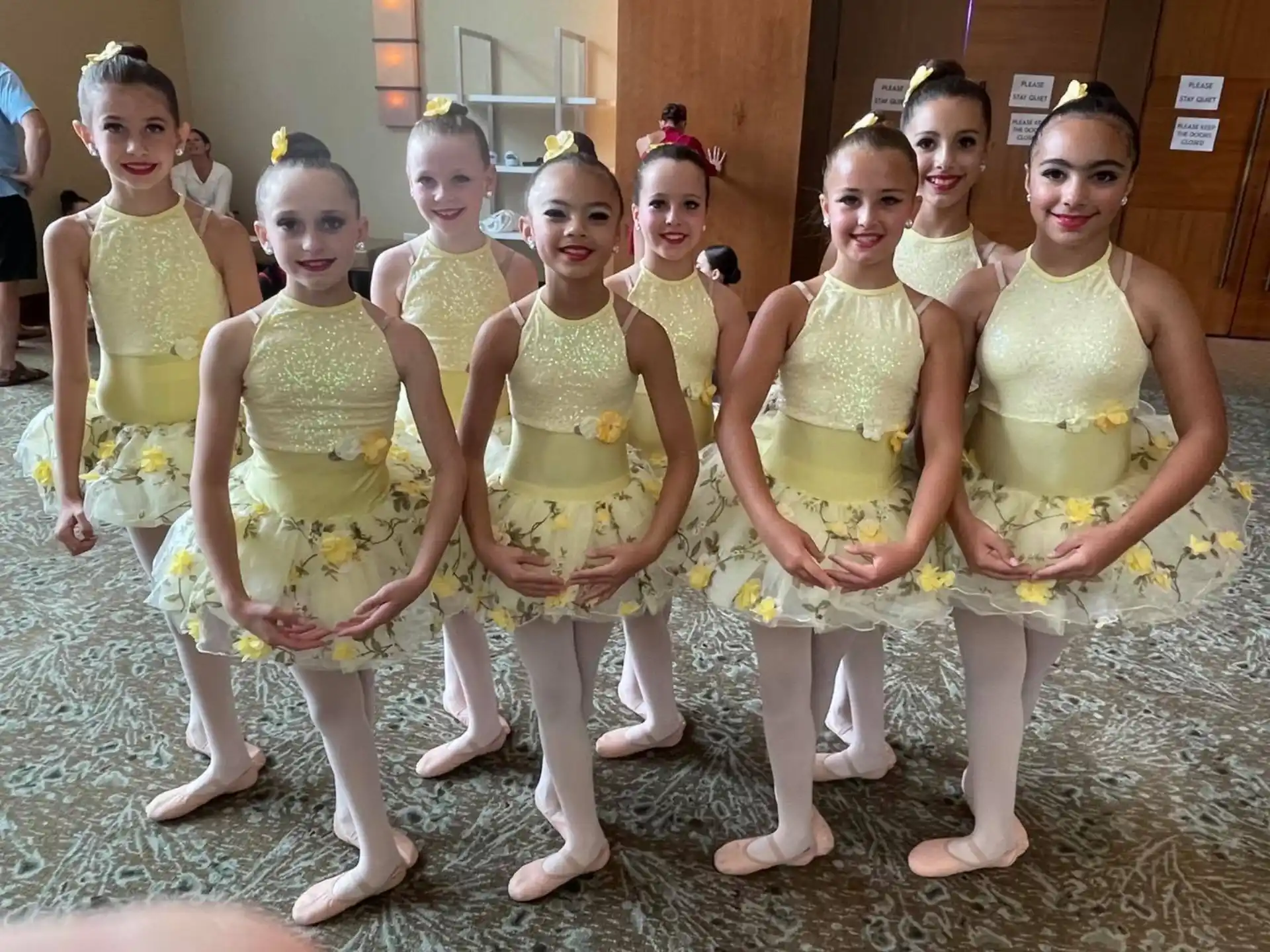 a group of women in yellow dresses