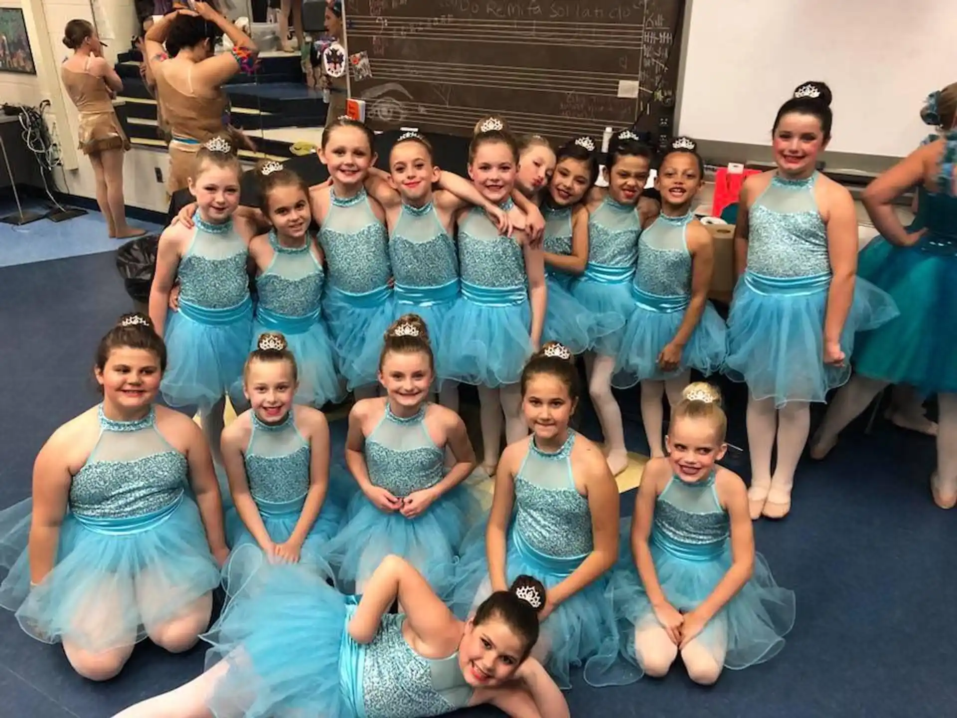 a group of girls in blue dresses