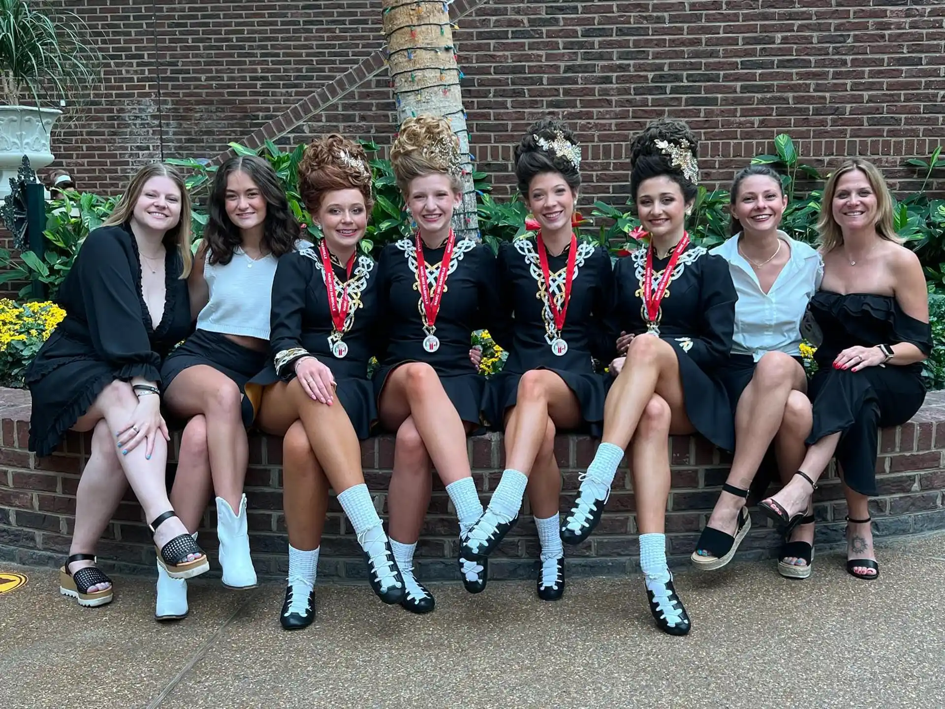 a group of people sitting on a bench posing for the camera