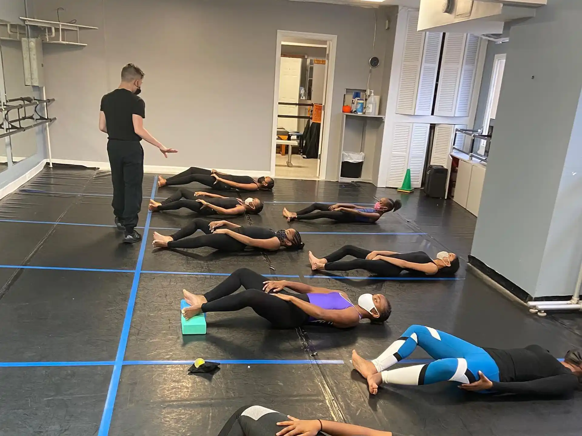 a group of people lying on the floor in a gym