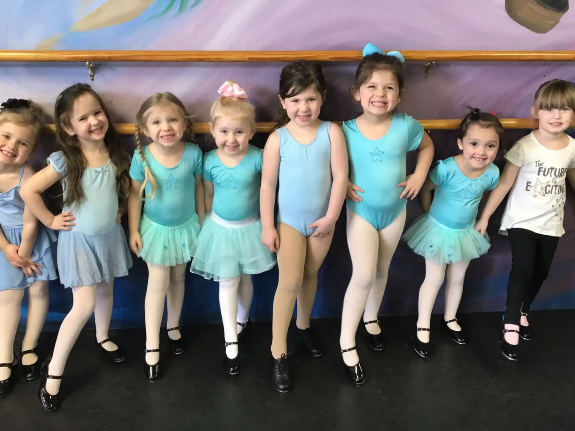 a group of girls in blue dresses