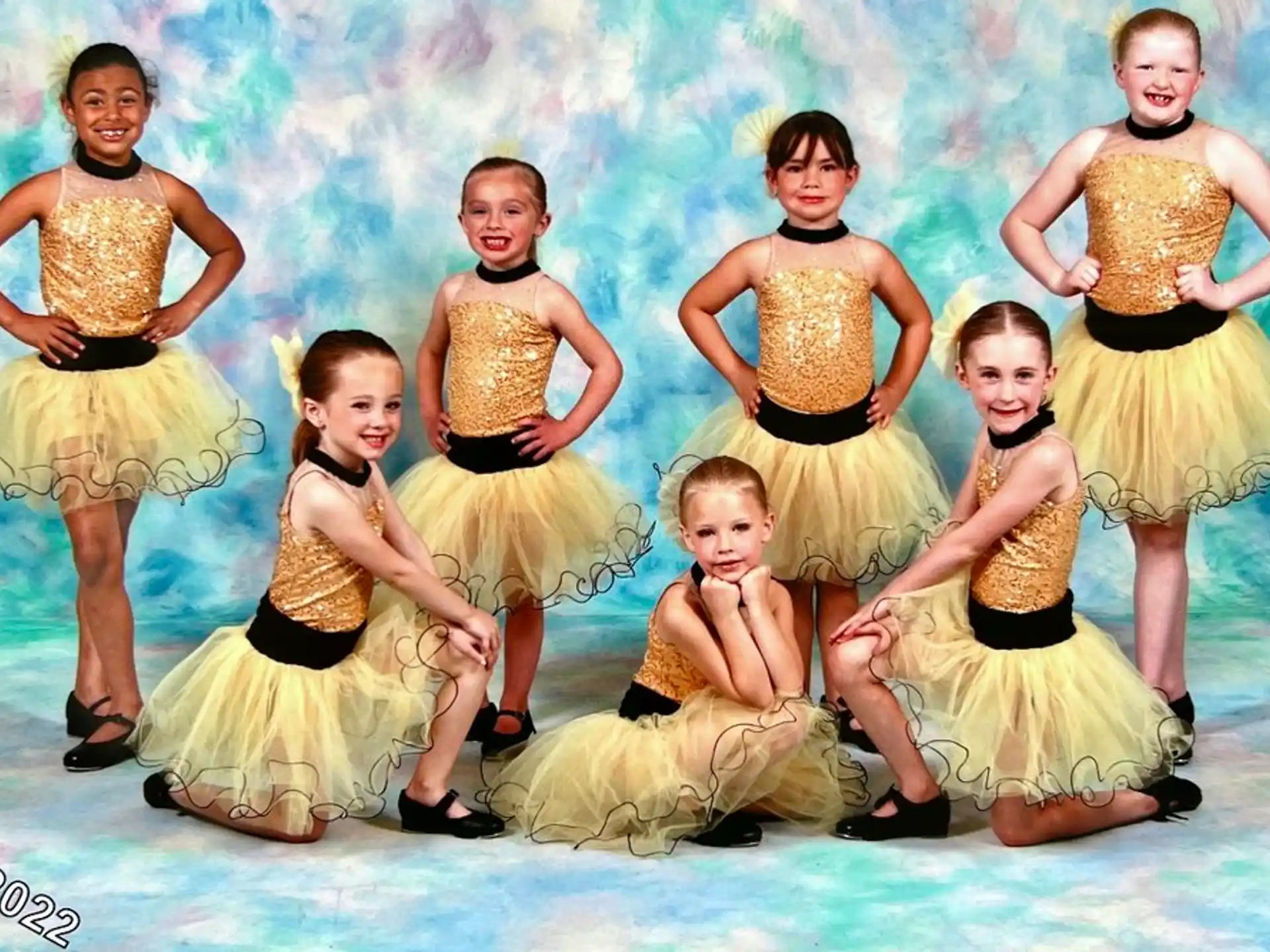 a group of women in yellow dresses