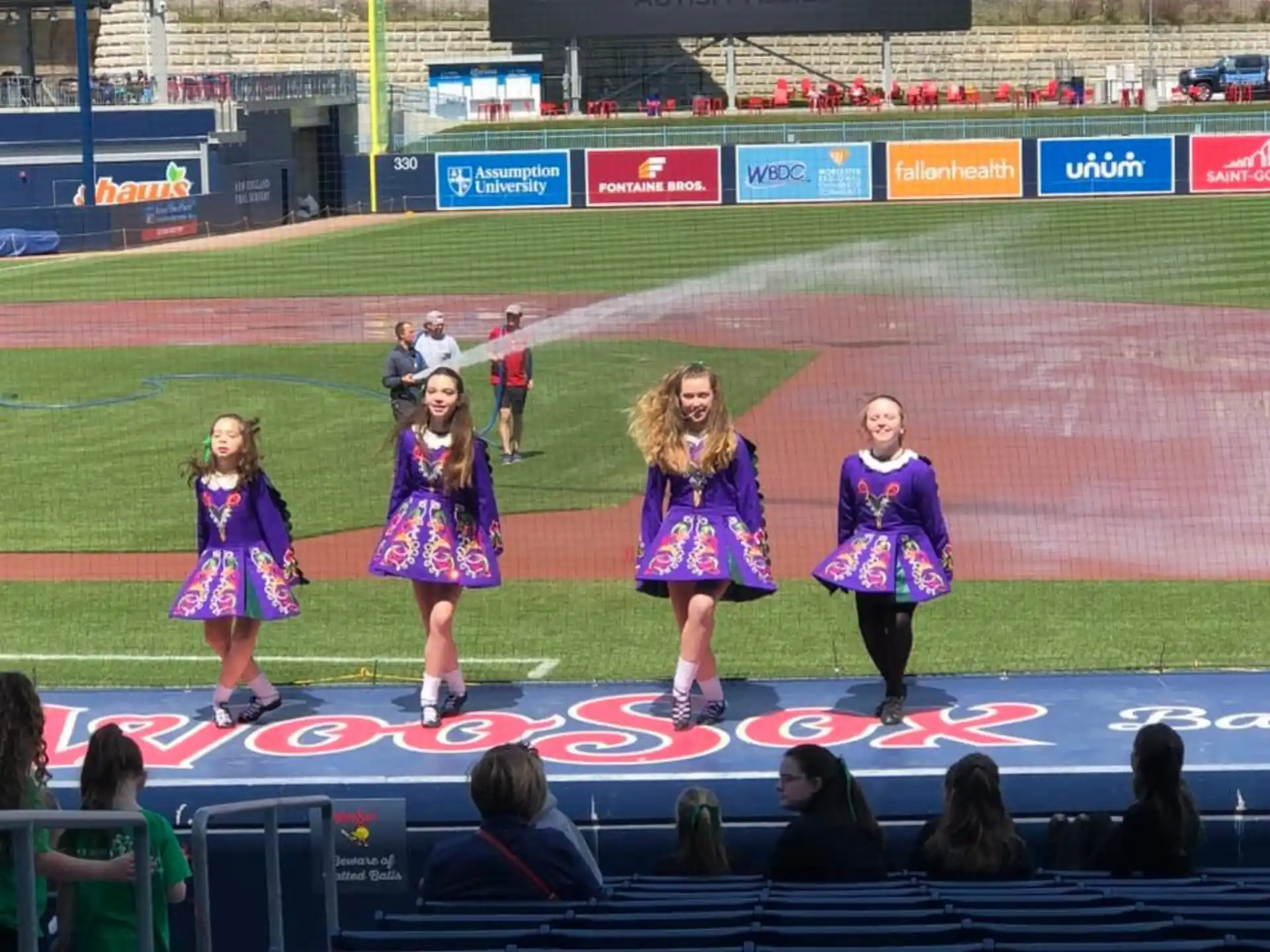a group of girls in purple uniforms on a track