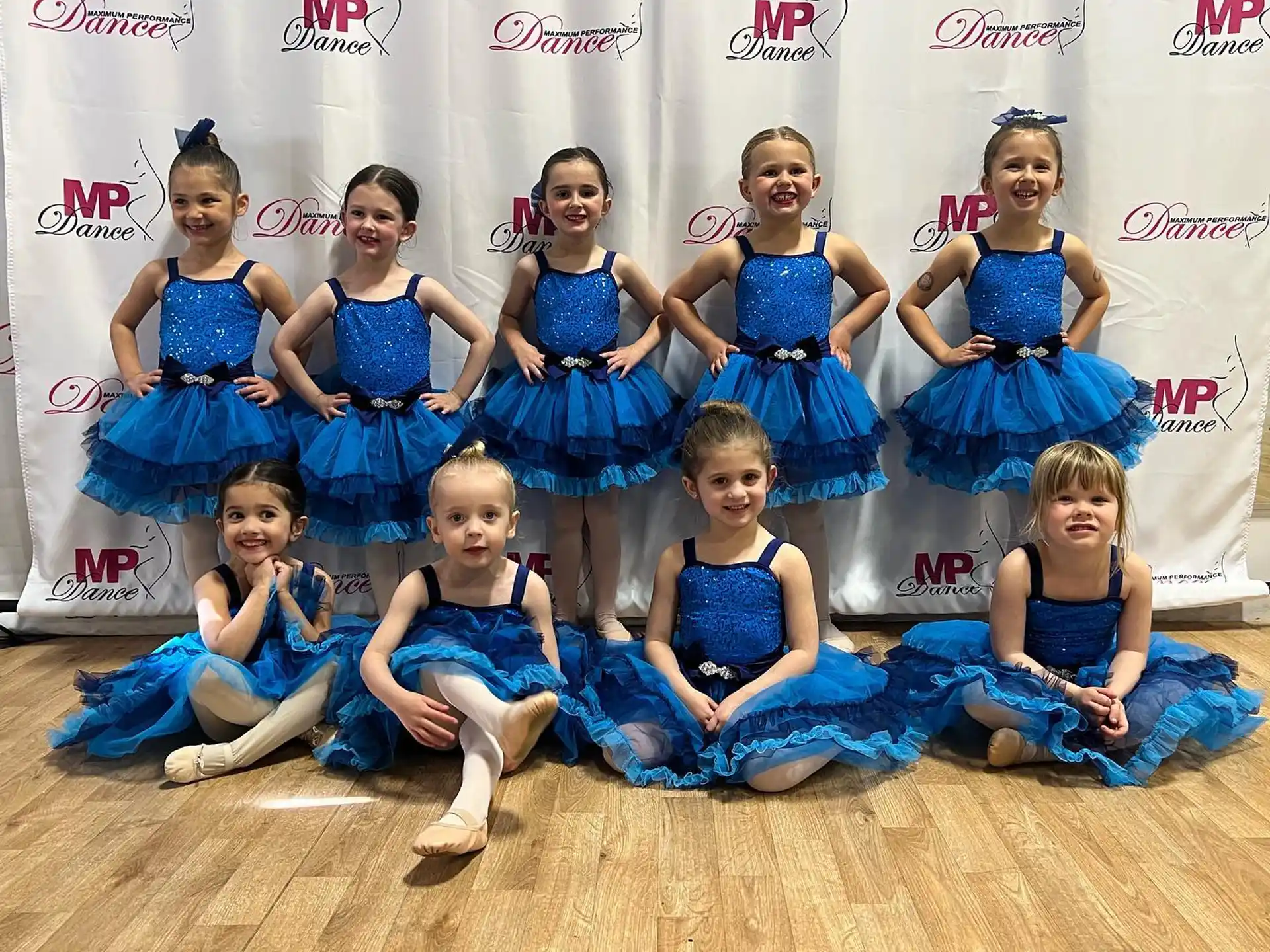a group of girls in blue dresses