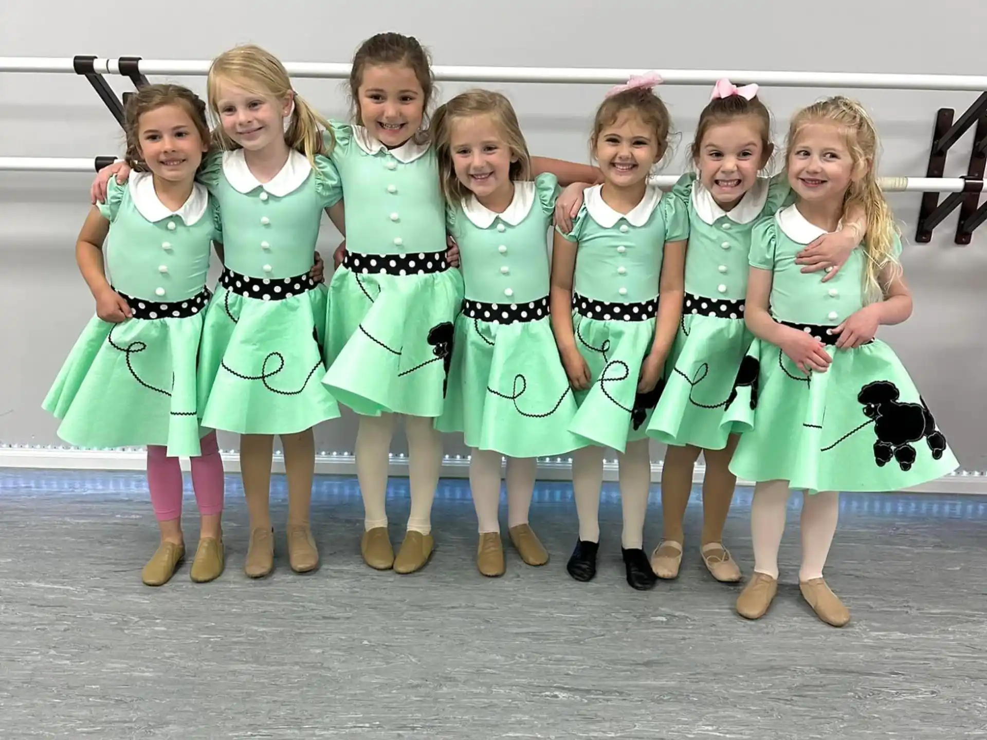 a group of girls in green dresses
