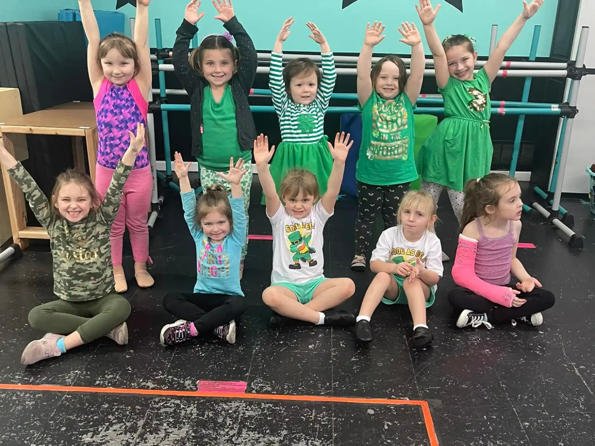 a group of children posing for a photo in front of a chalkboard