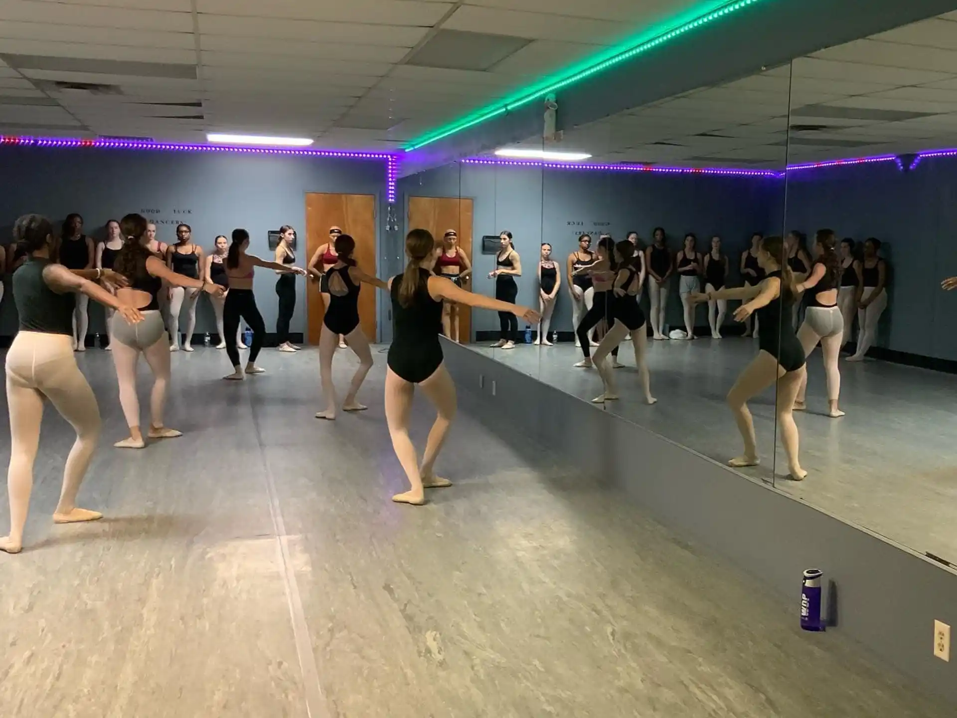 a group of people dancing in a room with purple walls