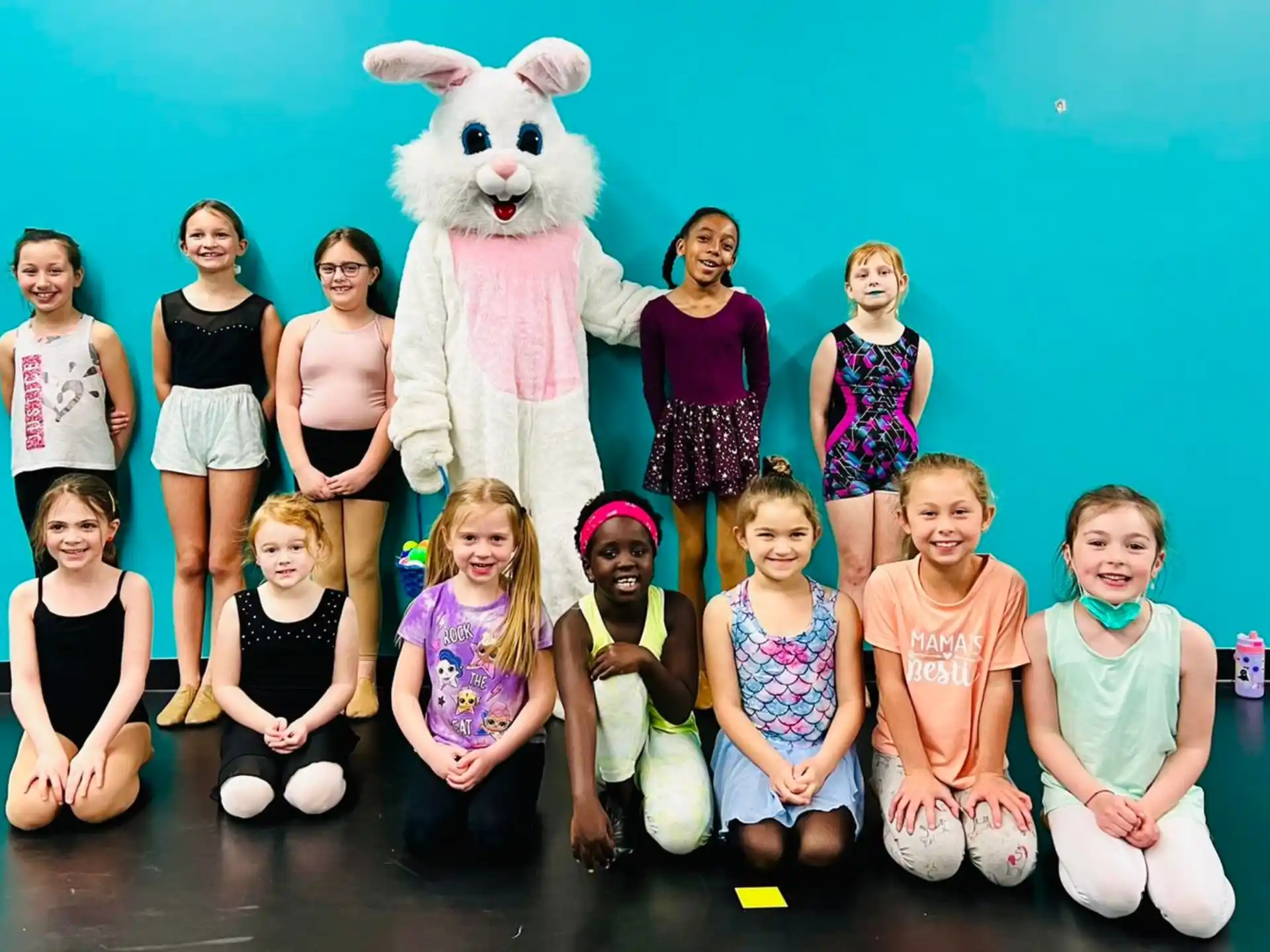 a group of people posing for a photo with a person in a rabbit garment