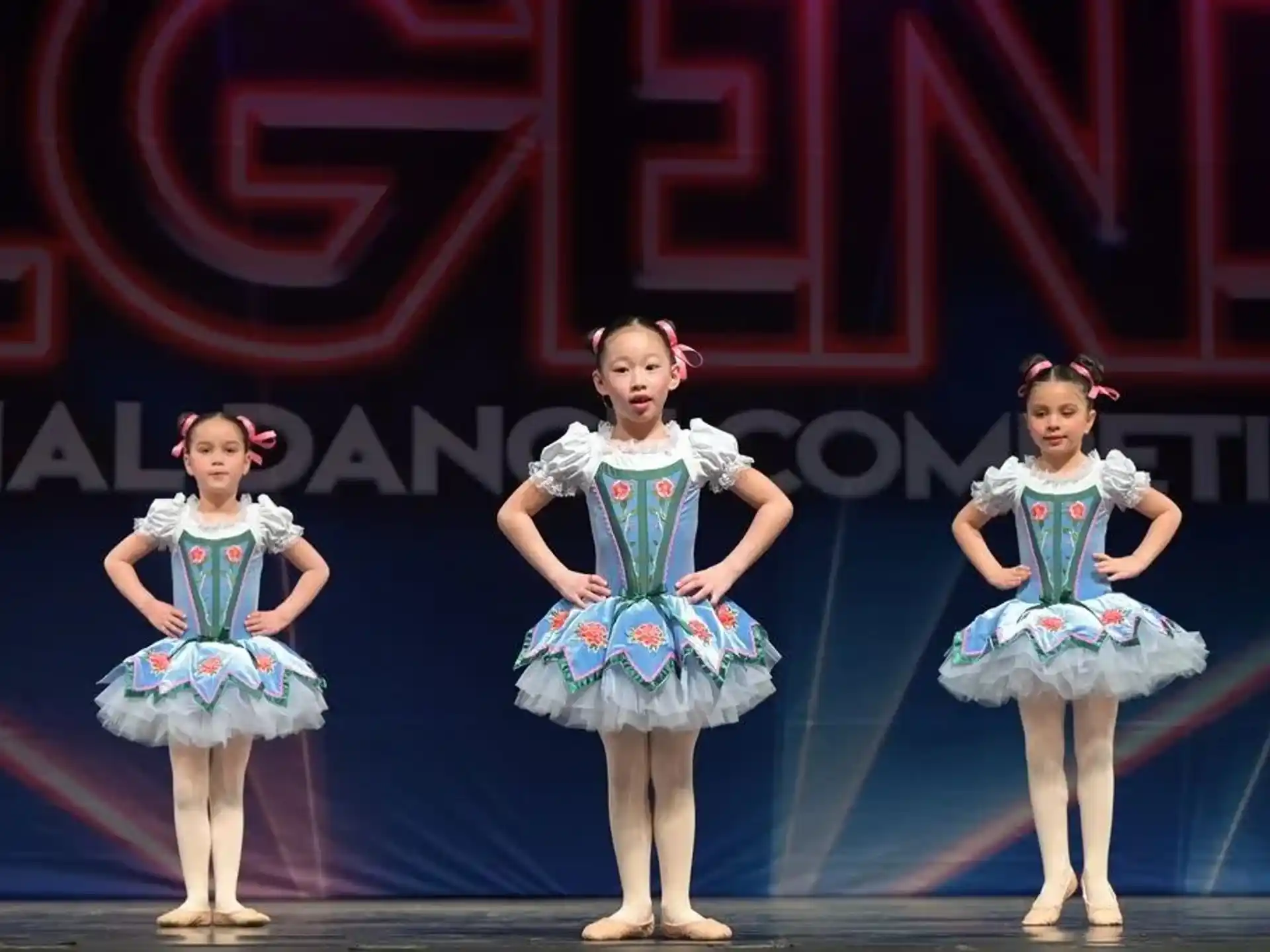 a group of girls in blue dresses on a stage