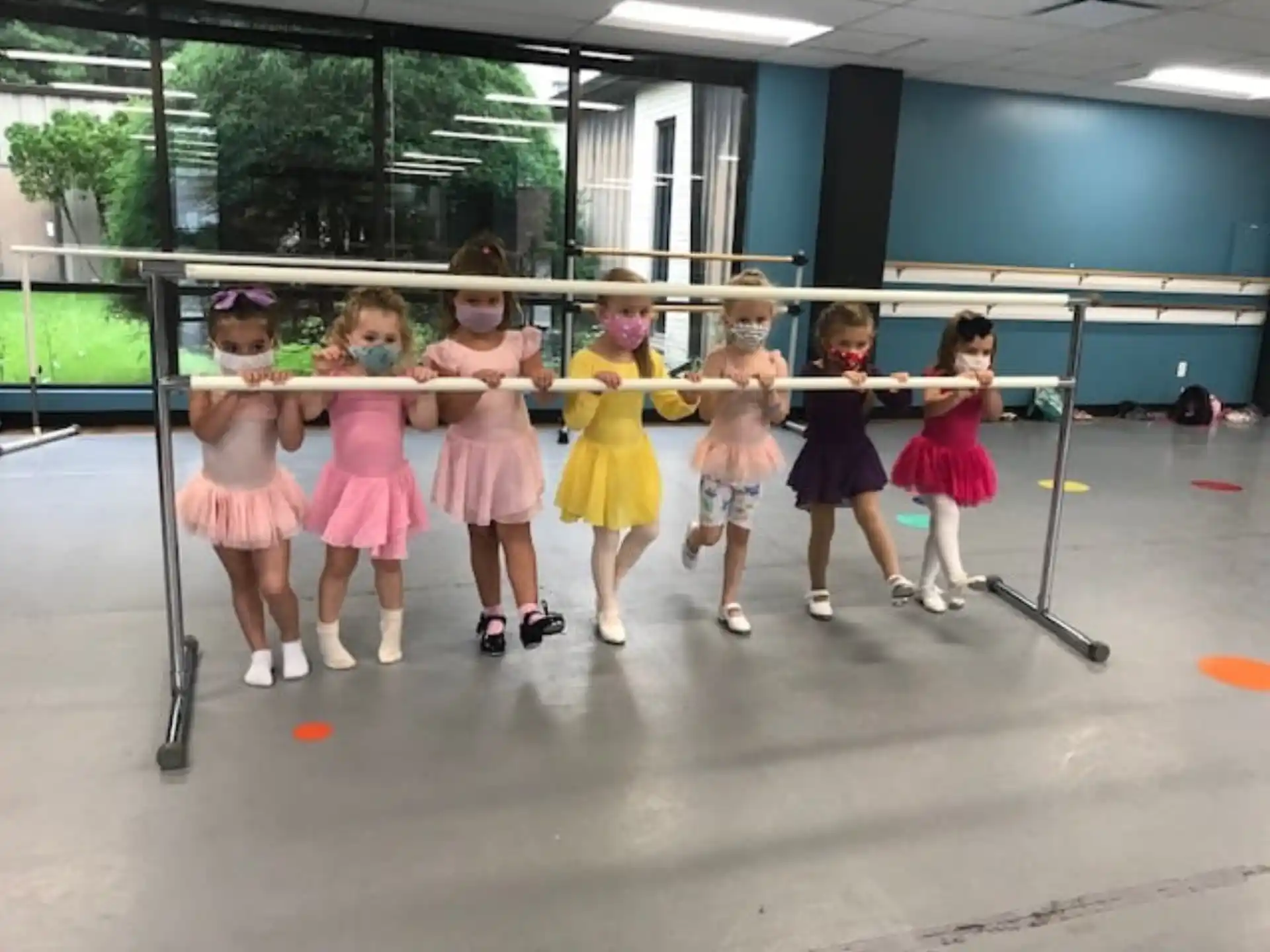 a group of girls in dresses and skirts on a stage