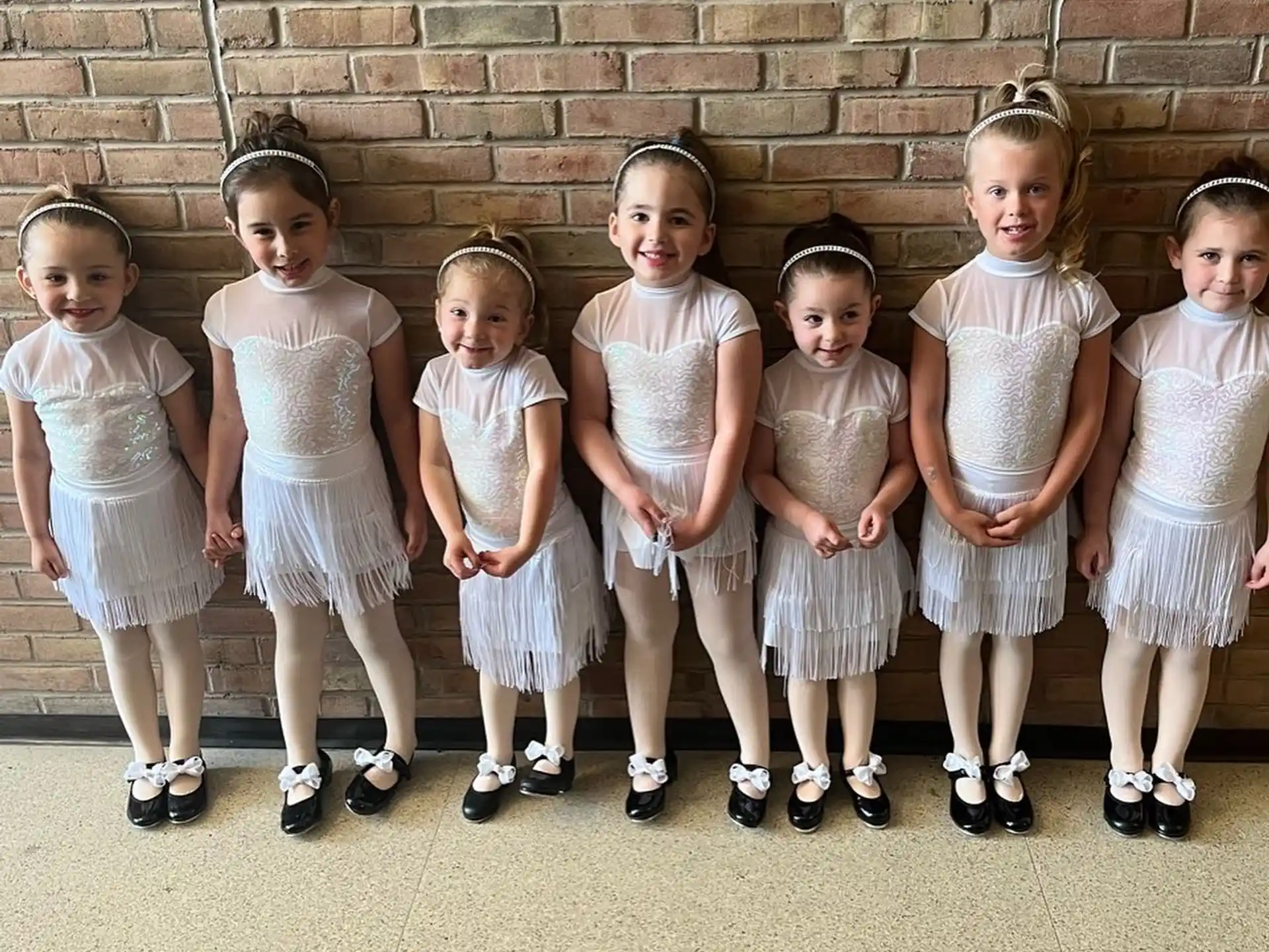 a group of girls in white dresses